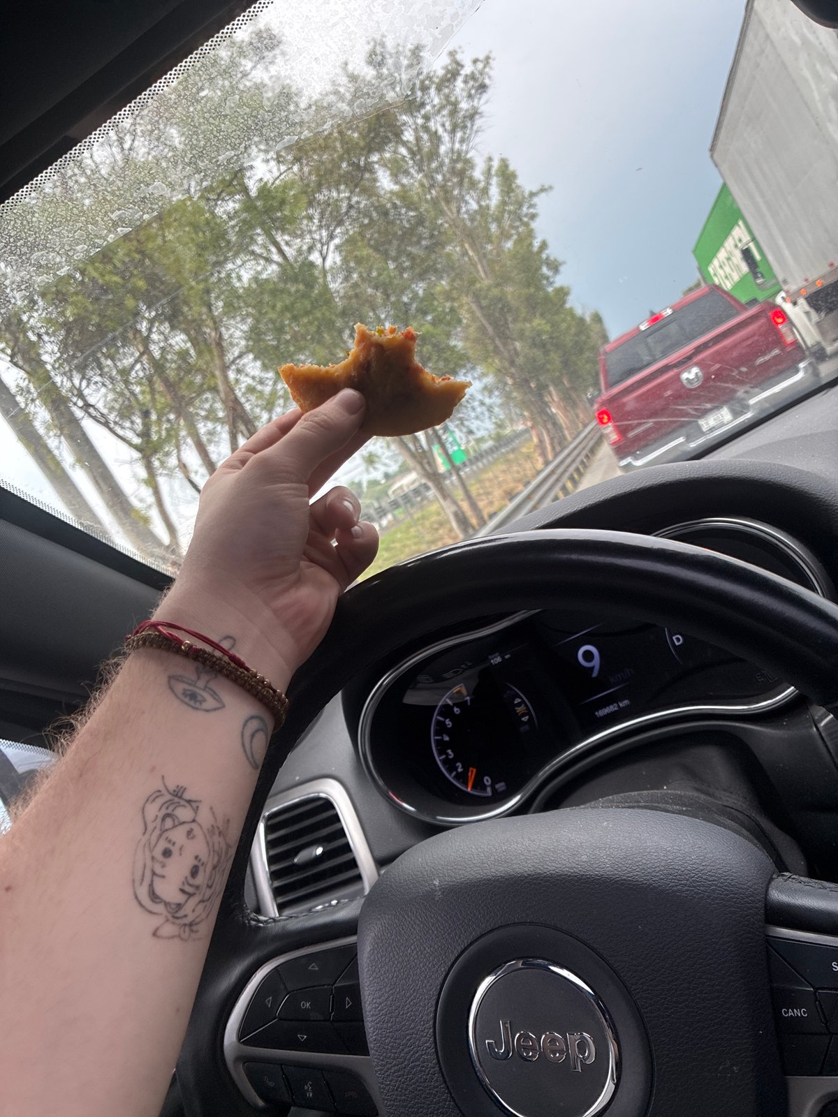 Person eats pastry in slow-moving Jeep in Tepotzotlán