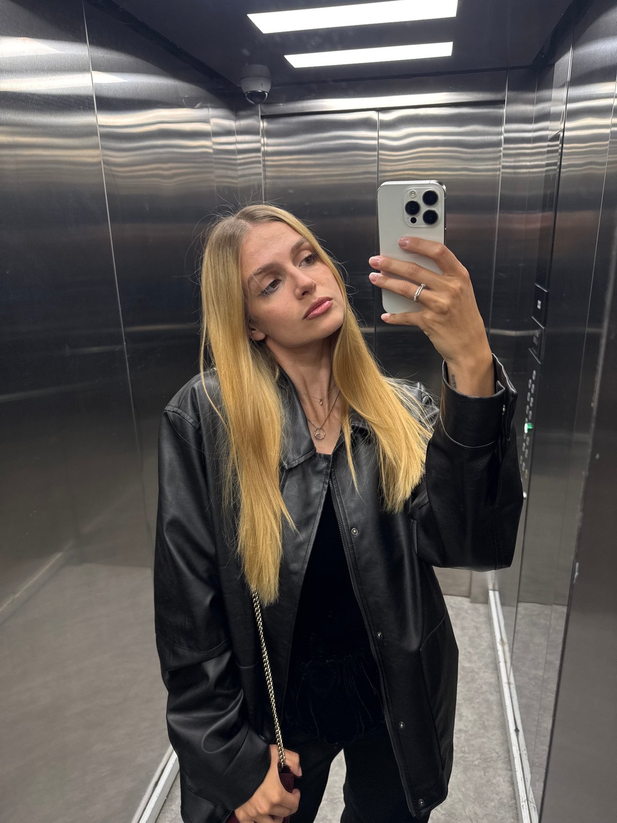 Woman takes selfie in stainless steel elevator