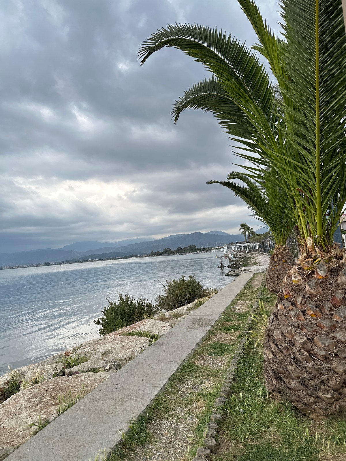 Tourist photographs herself at Fethiye waterfront during early morning