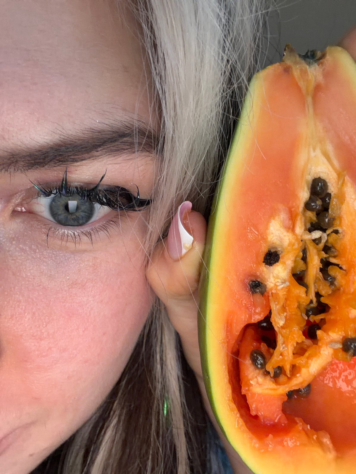 Woman photographed with halved papaya fruit in Budva, Montenegro