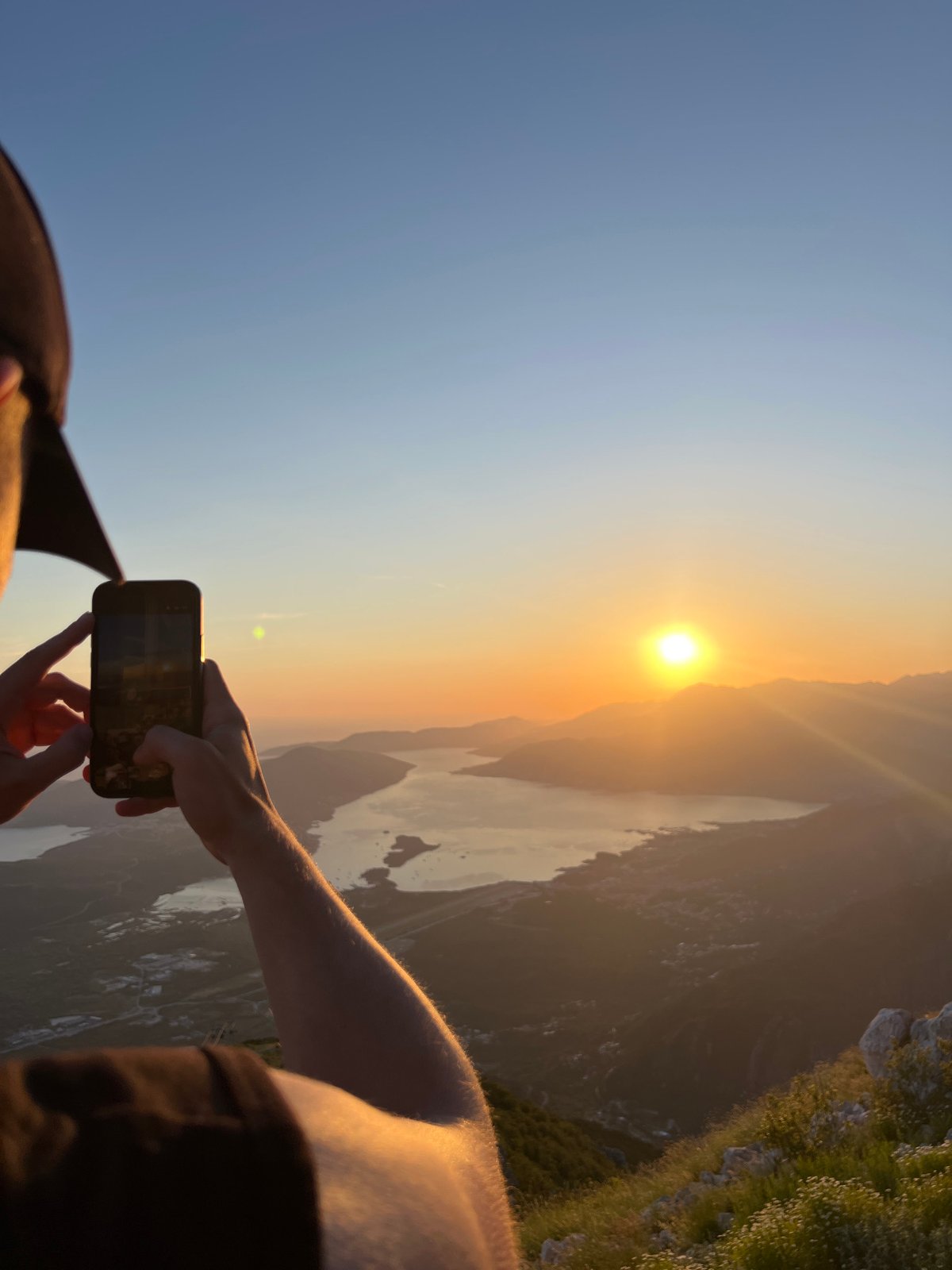 Tourists photograph sunset at Bay of Kotor viewpoints Montenegro