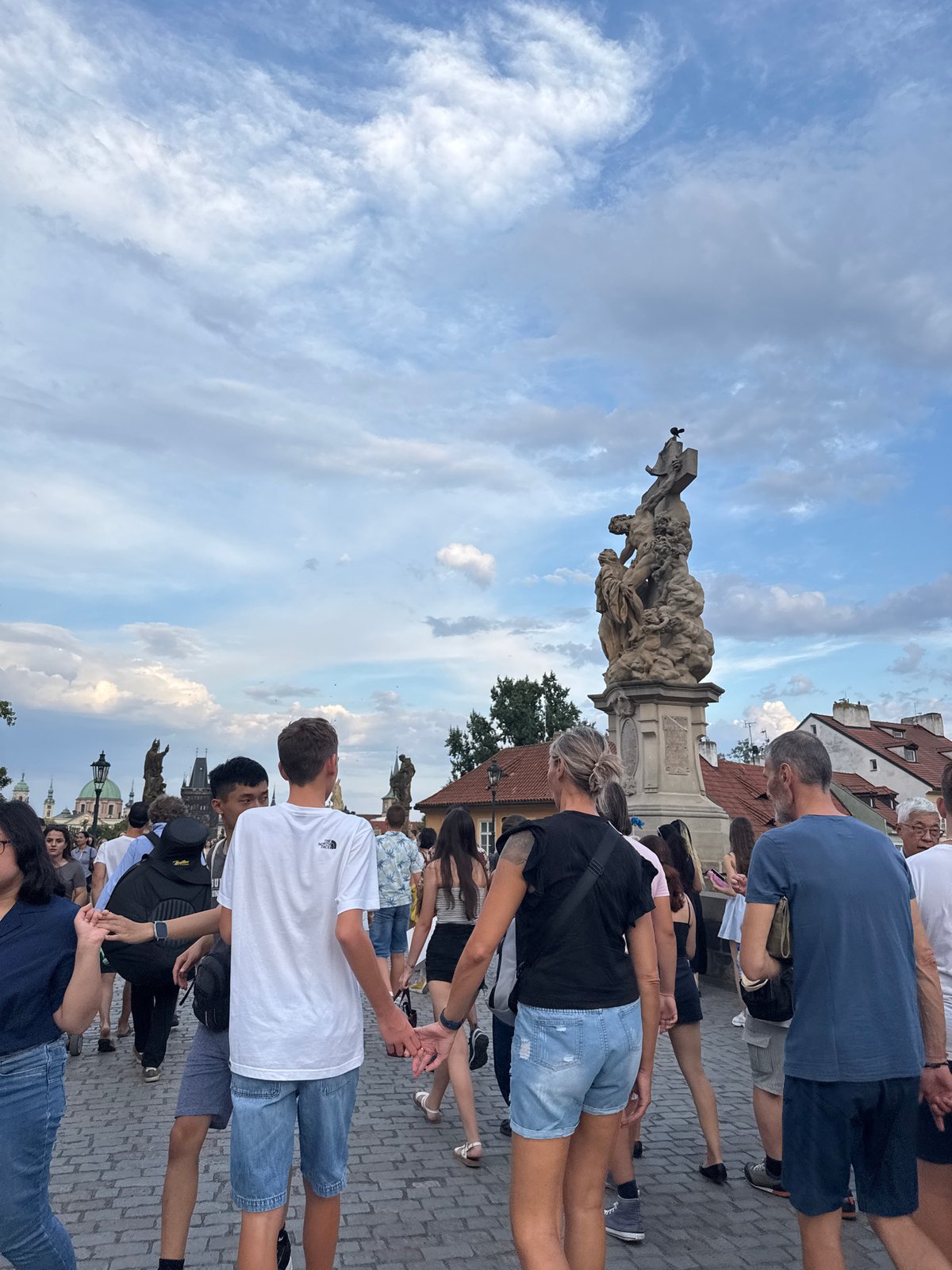 Charles Bridge crowds under dramatic summer skies, Prague