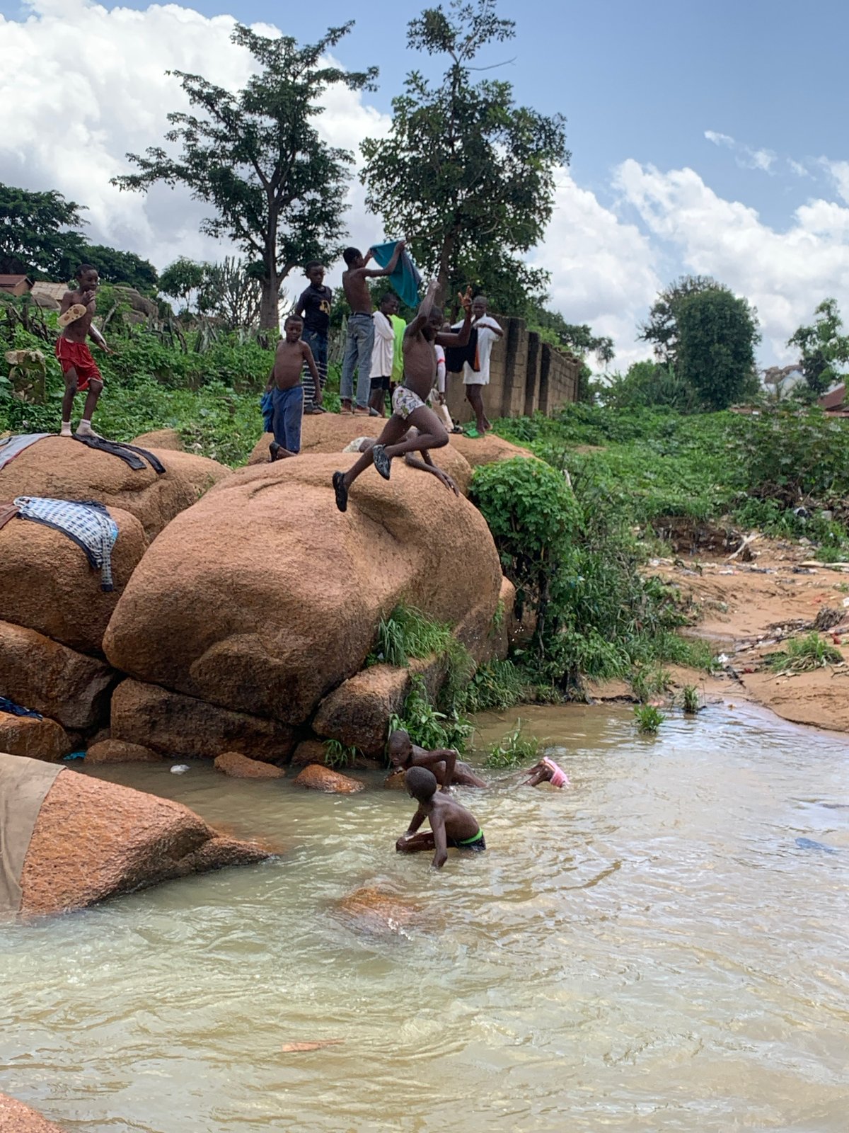 Kids in rocky Jos streams, streets, and farmland on a July morning