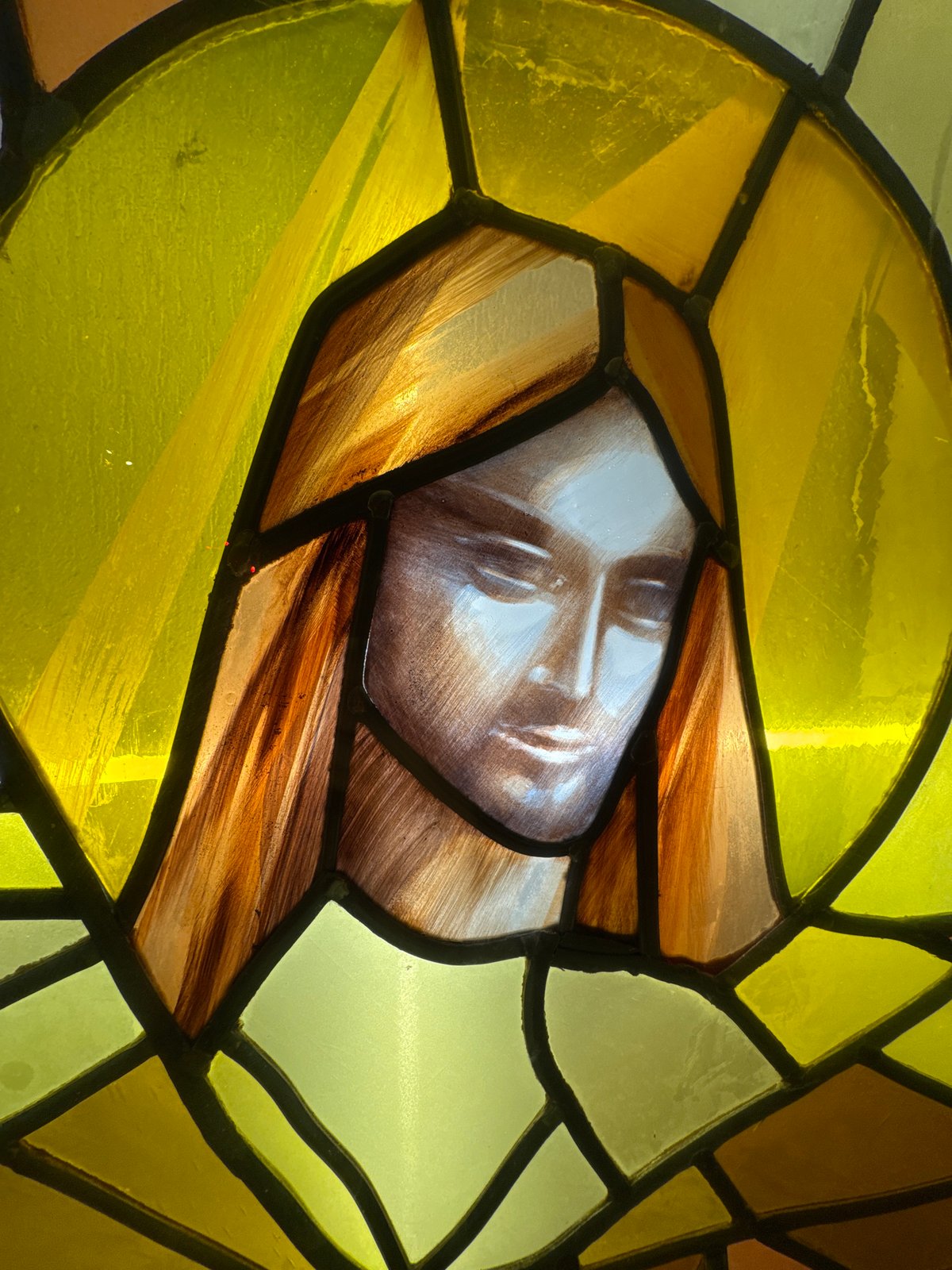 Stained glass religious figure with golden halo documented in Paris