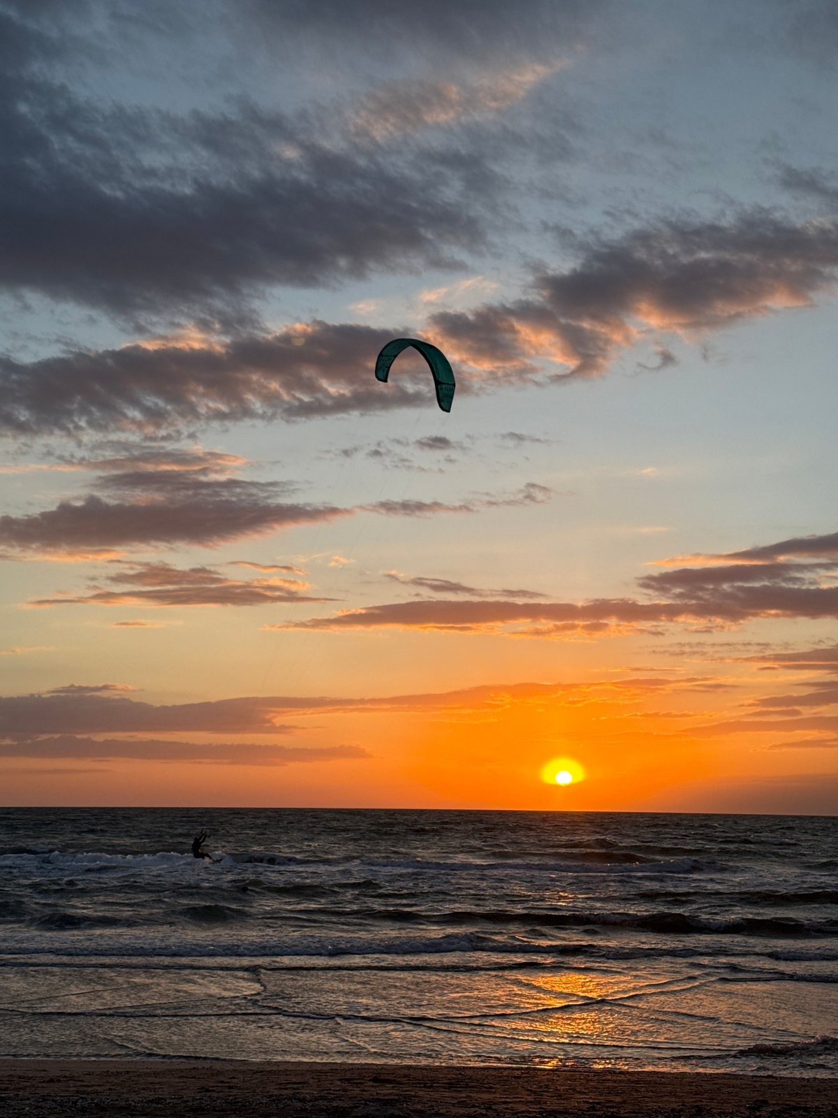 Kite surfers ride sunset waters near Shchelkino, Ukraine