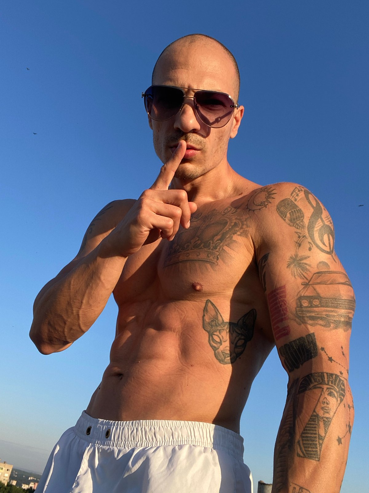 Tattooed figure poses under open sky in Pleven