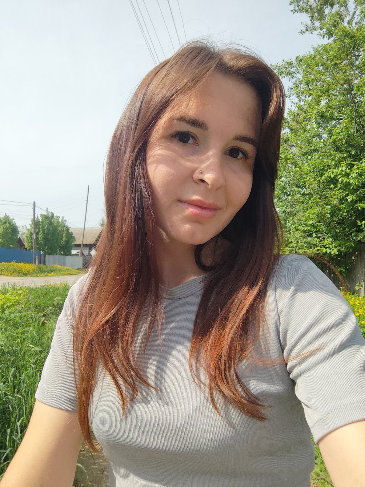 Woman takes selfie among wildflowers in rural Russia