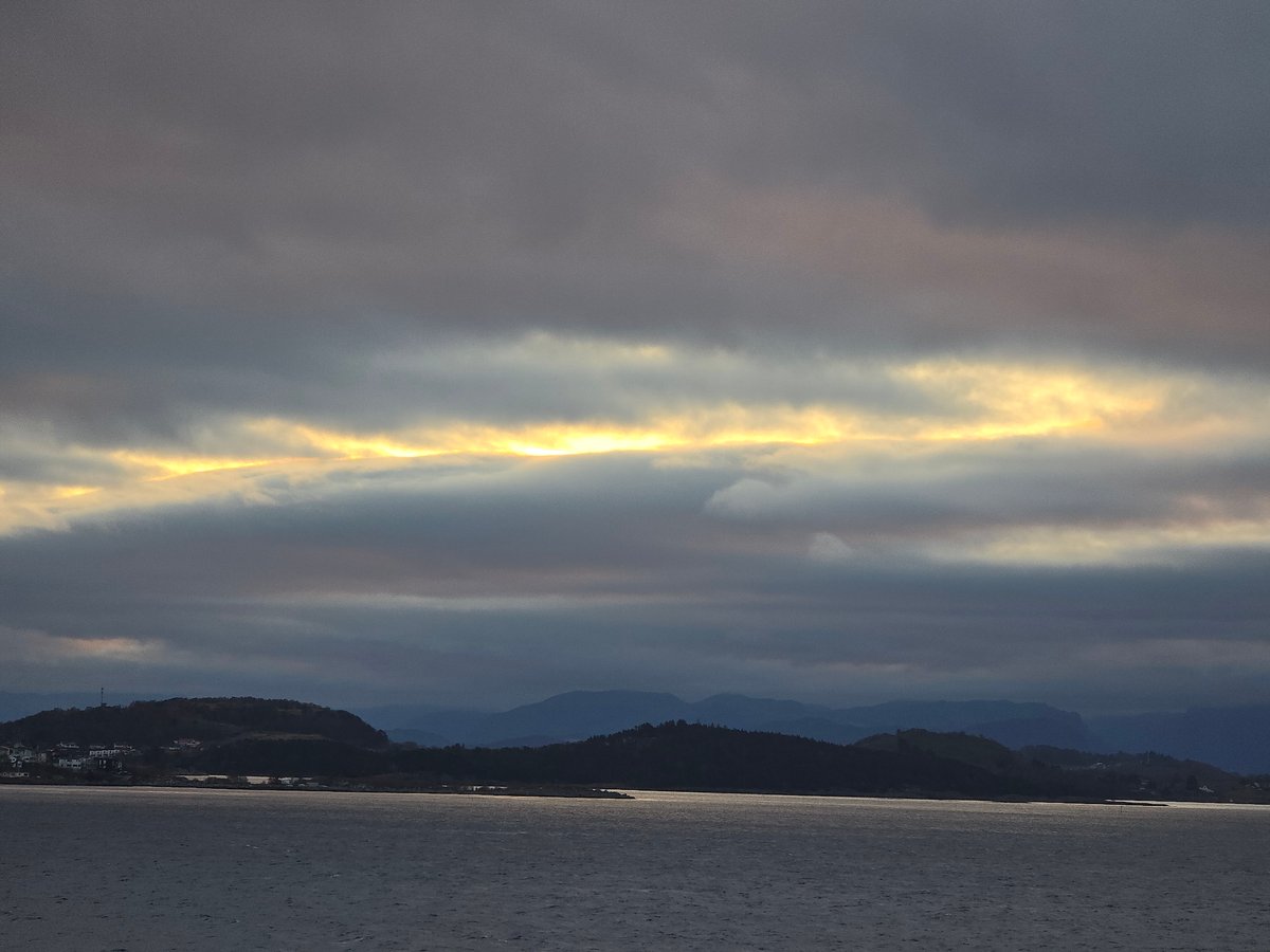 Dawn breaks through storm clouds over Norwegian coast