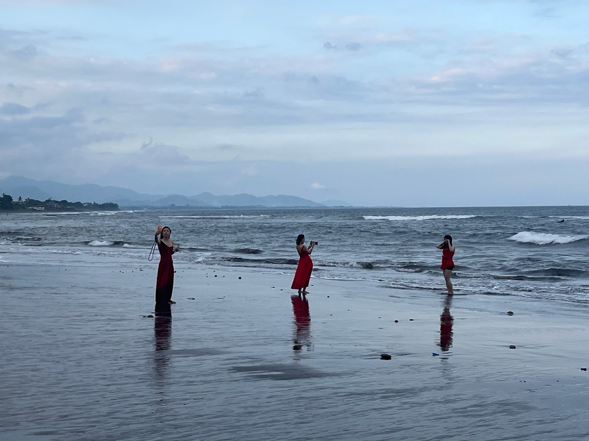 Dark sand beach and temple on a cloudy Bali morning