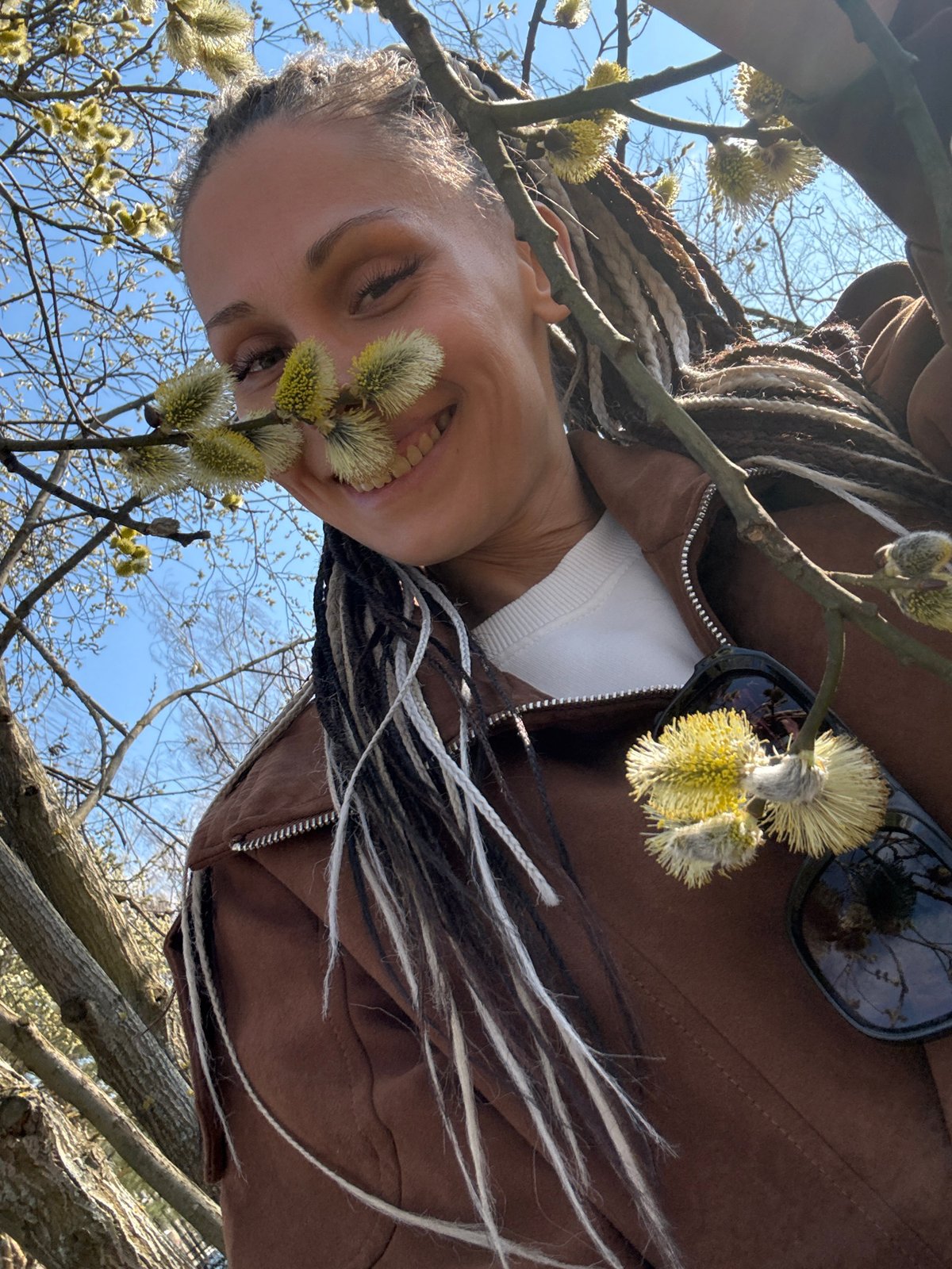 Woman photographed smiling among spring tree blossoms in Rusanovo