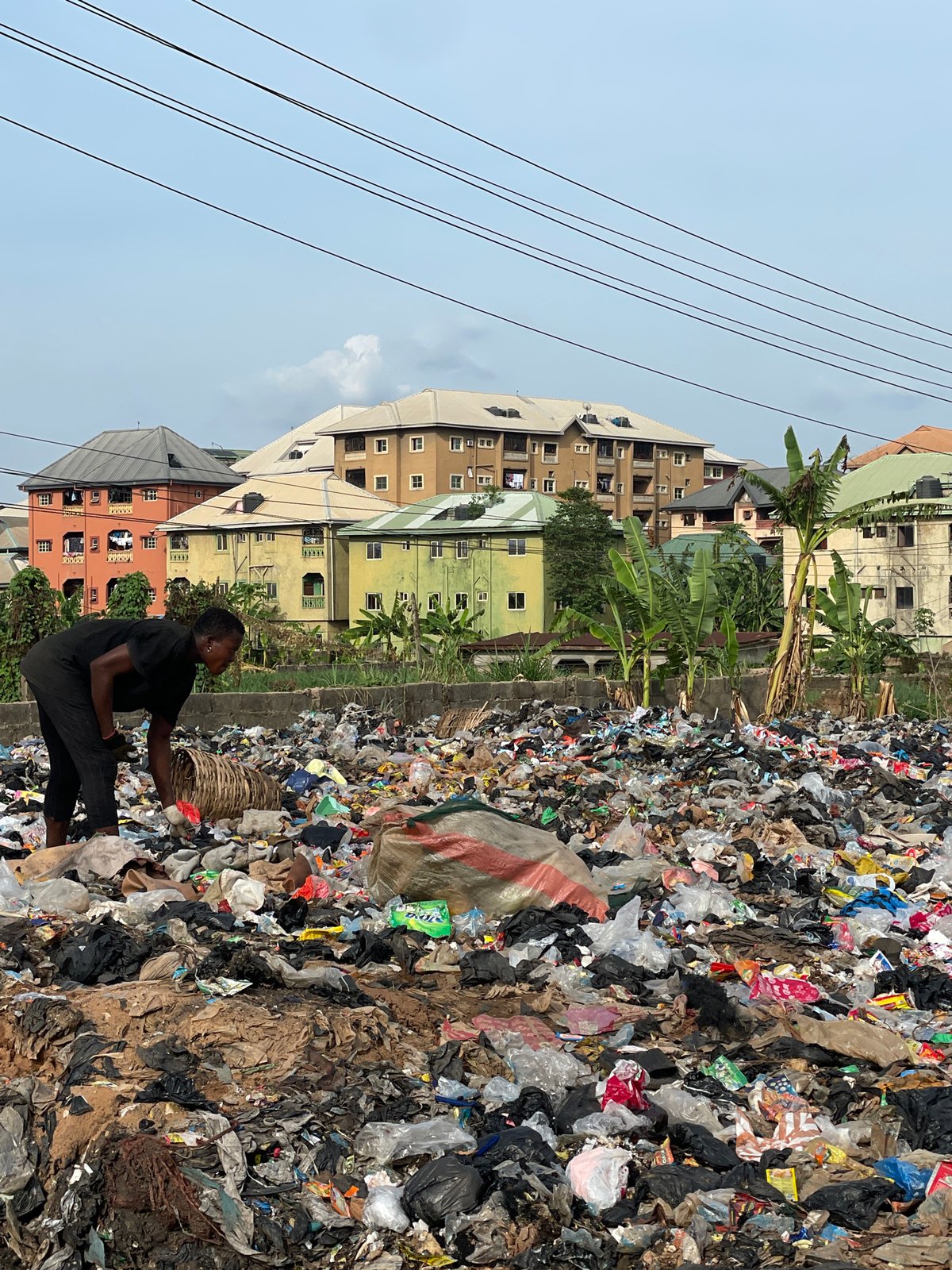 Woman sorts through trash pile in Onitsha, Nigeria