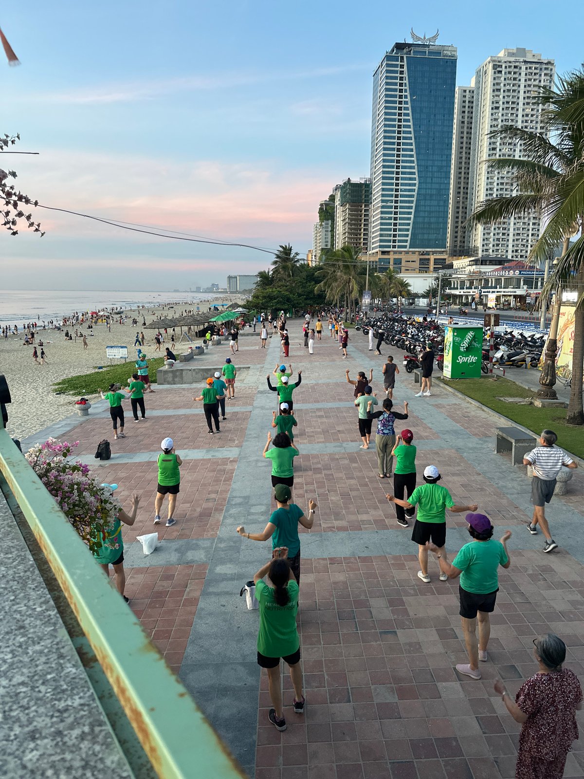 Mỹ Khê Beach at golden hour — crowds, exercise, and ocean views