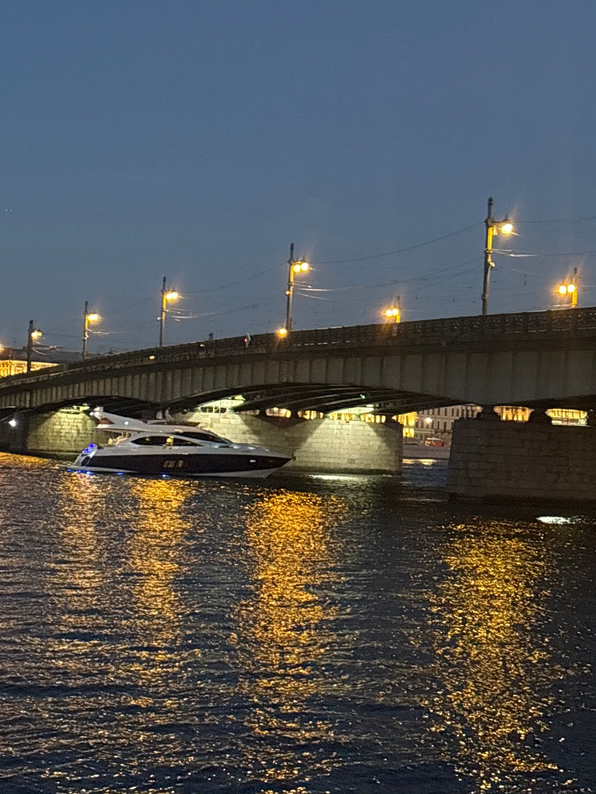 White yacht cruises the Neva River on a St. Petersburg summer night