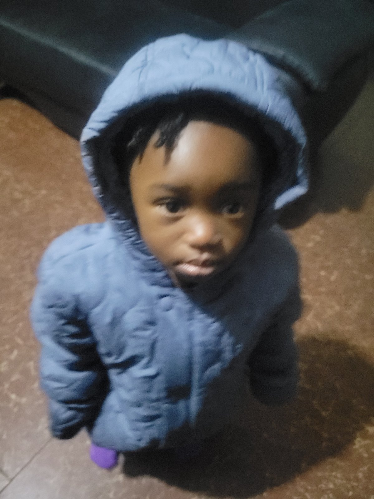 Child in blue jacket and adult observed indoors