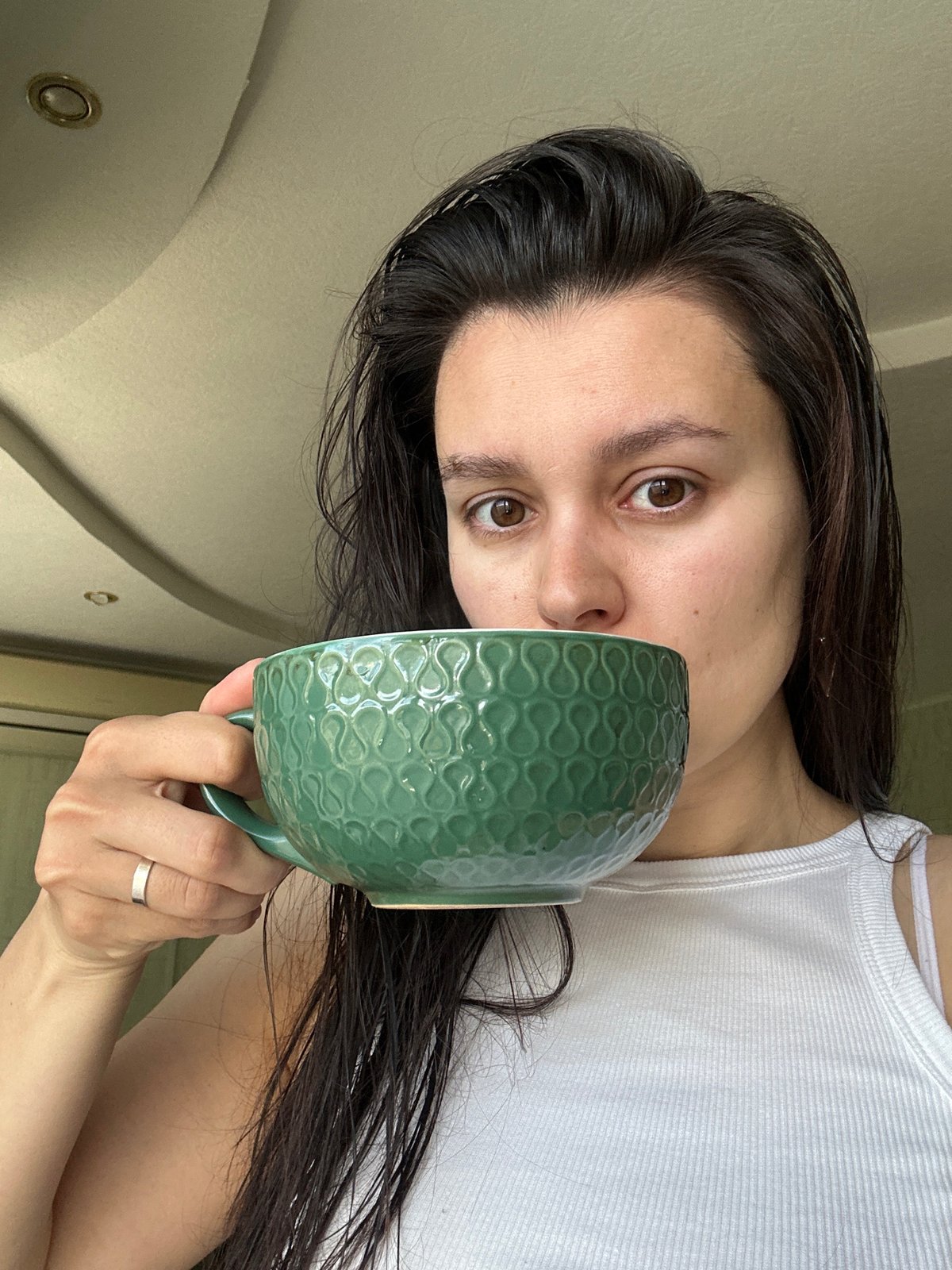 Woman drinks from green mug in early morning Chaikovsky