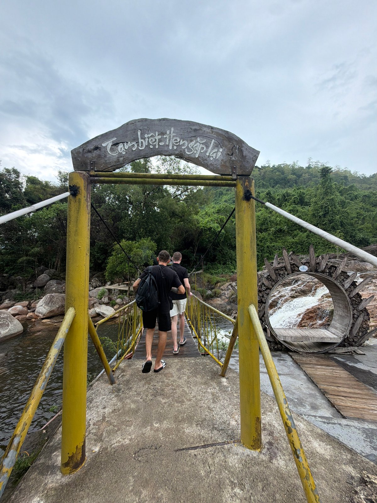 Two men explore Yang Bay Waterfall Park in Vietnam