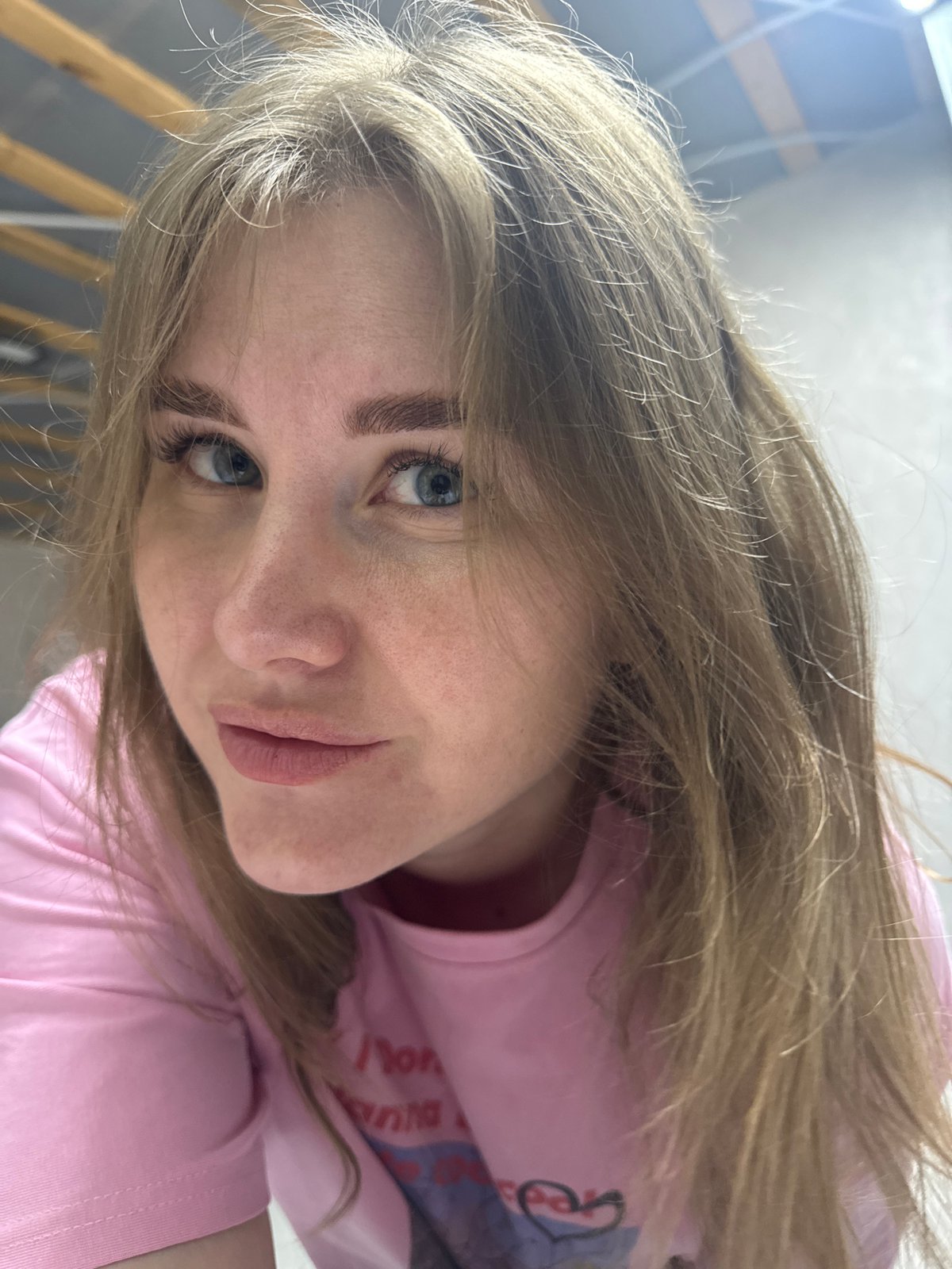 Woman in pink "I Don't Wanna Hate" shirt photographed in Gornyi
