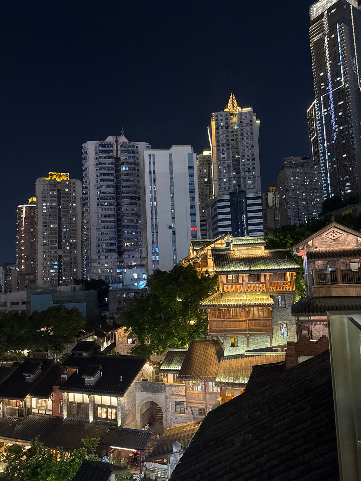 Hongyadong's traditional architecture glows against Chongqing's modern skyline