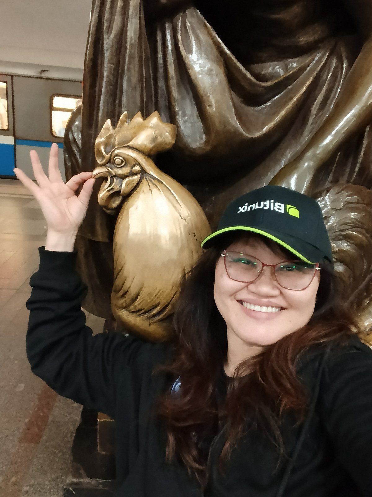 Tourists photograph bronze statues in decorated underground space