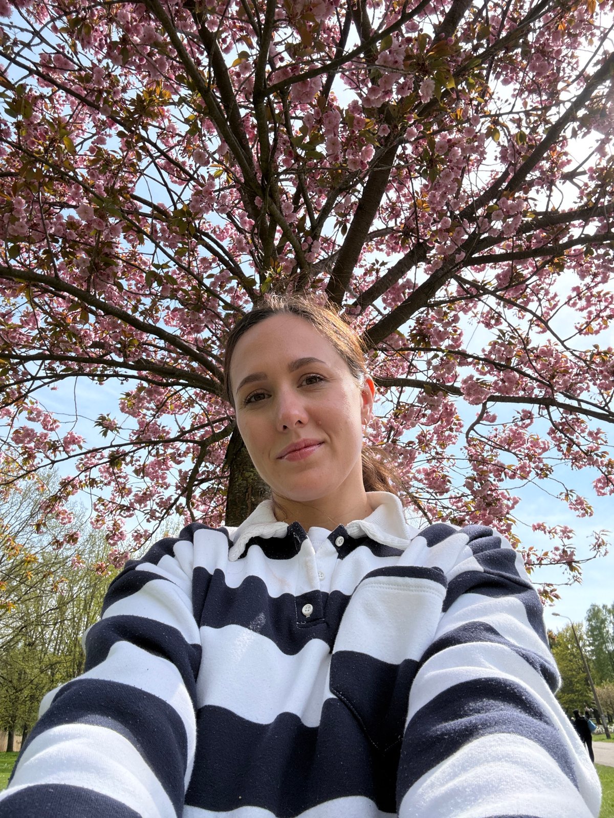 Woman enjoys spring blossoms under flowering tree in Riga