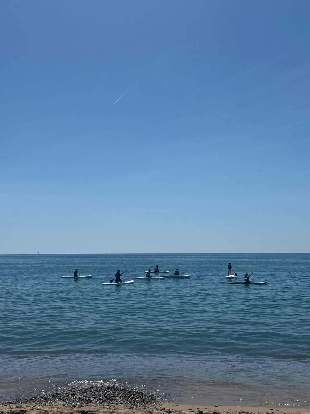 Barcelona residents enjoy morning paddleboarding and skateboarding activities