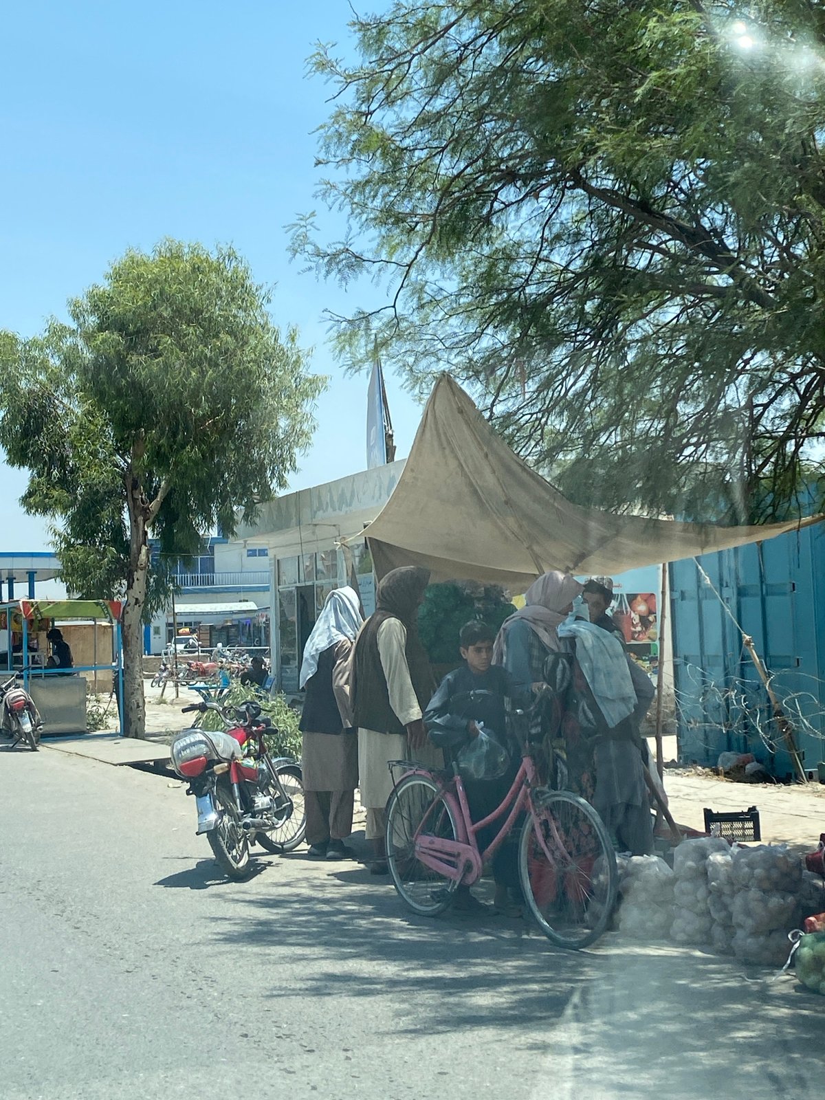 Market activity and parked vehicle on Kandahar street