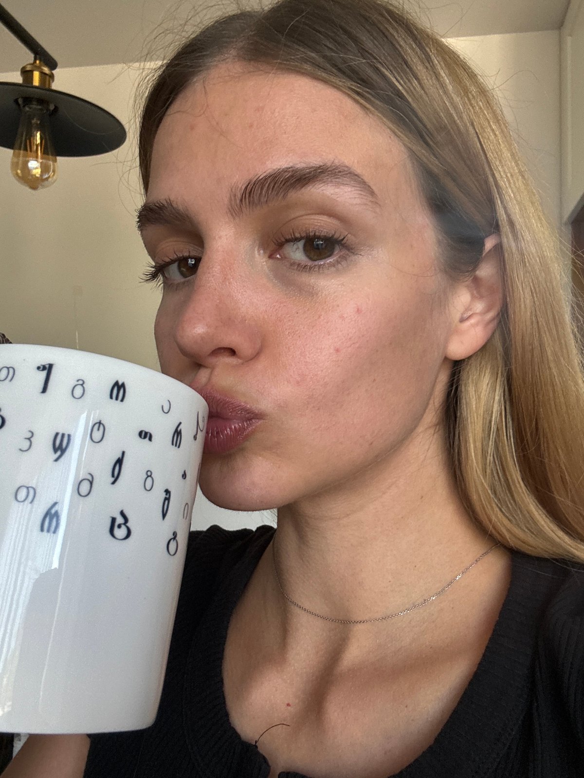 Woman holds numbered mug at dawn coordinates