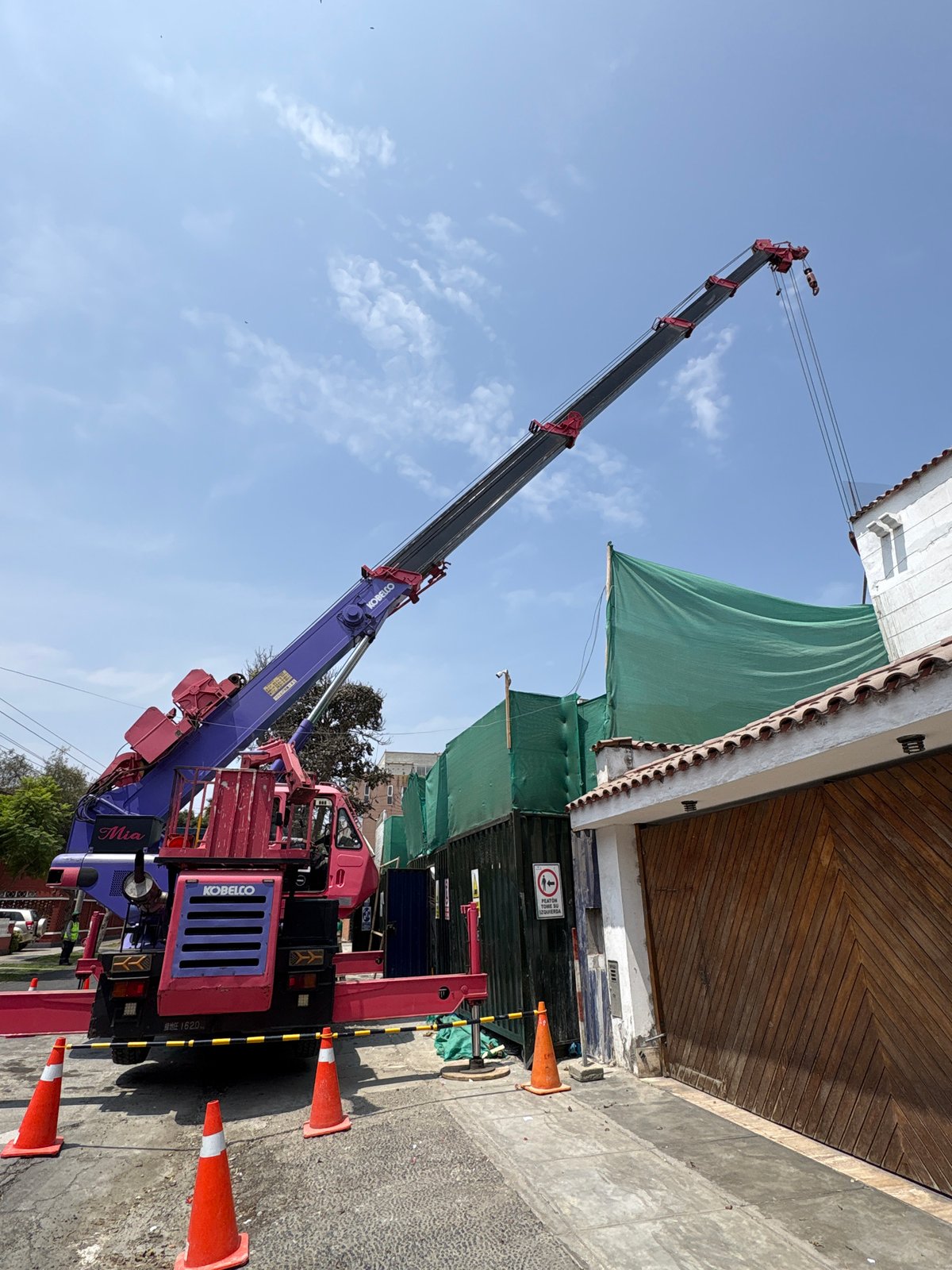 Construction crane operates on Miraflores street with building work