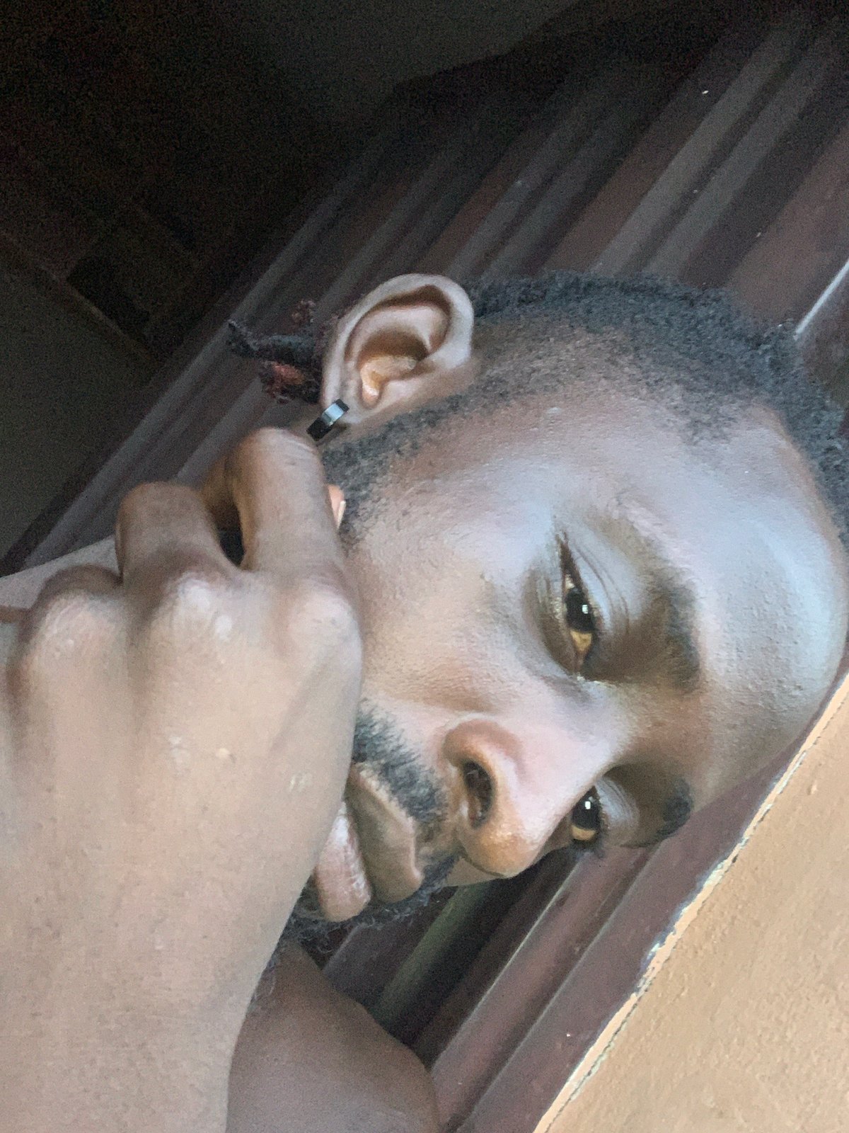 Man photographed with hand covering mouth in Lekki