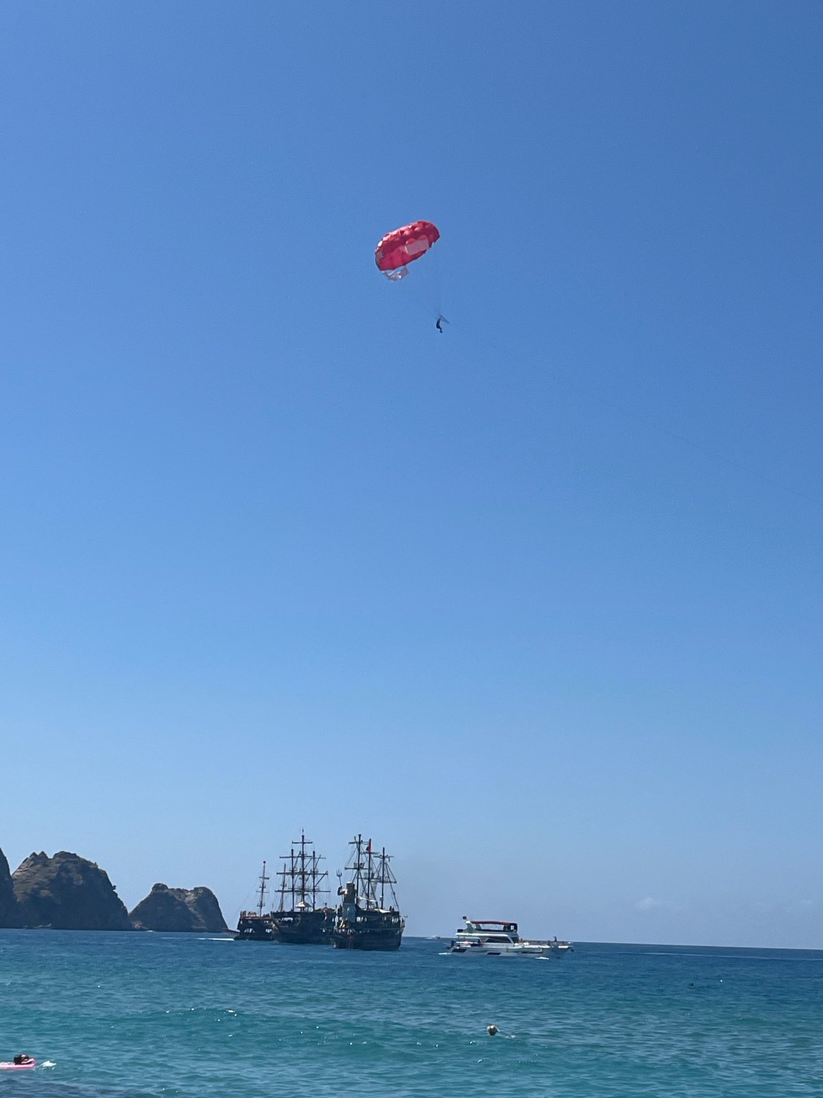 Parasailing activity captured over busy Alanya beach on sunny morning