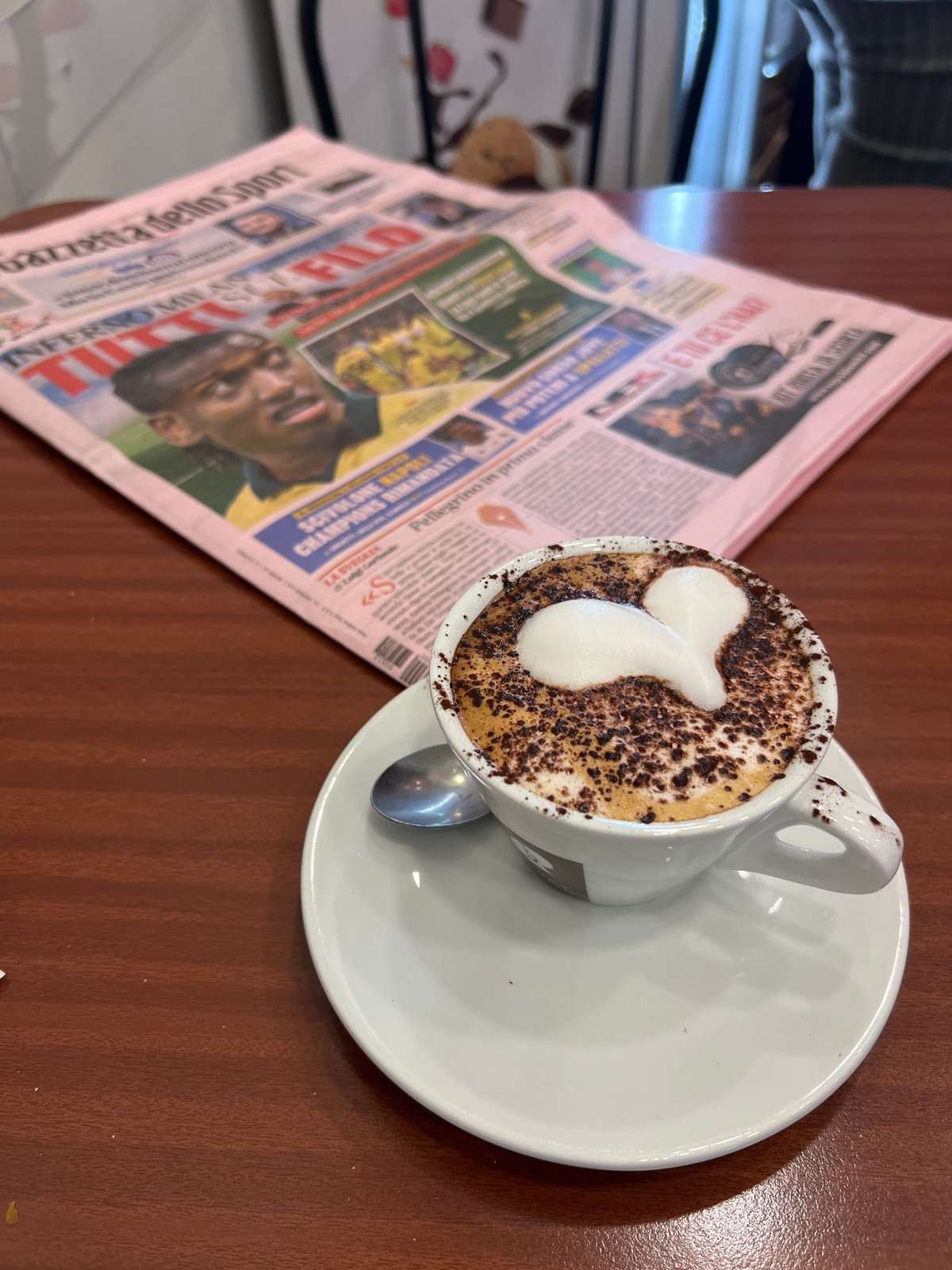 Morning cappuccino with foam art served in Milan cafe