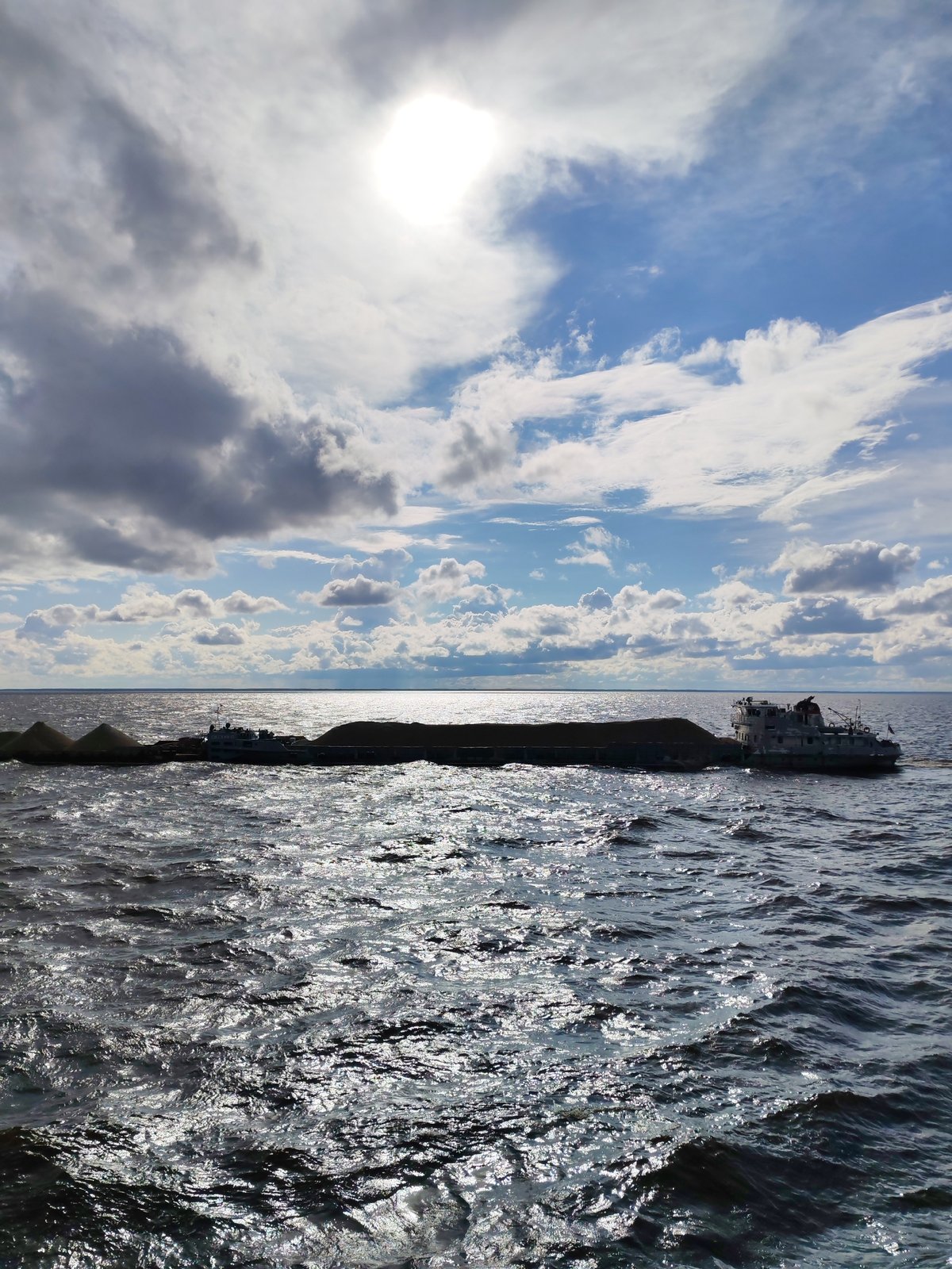 Barges and tugboats working a Russian waterway, rainbow included