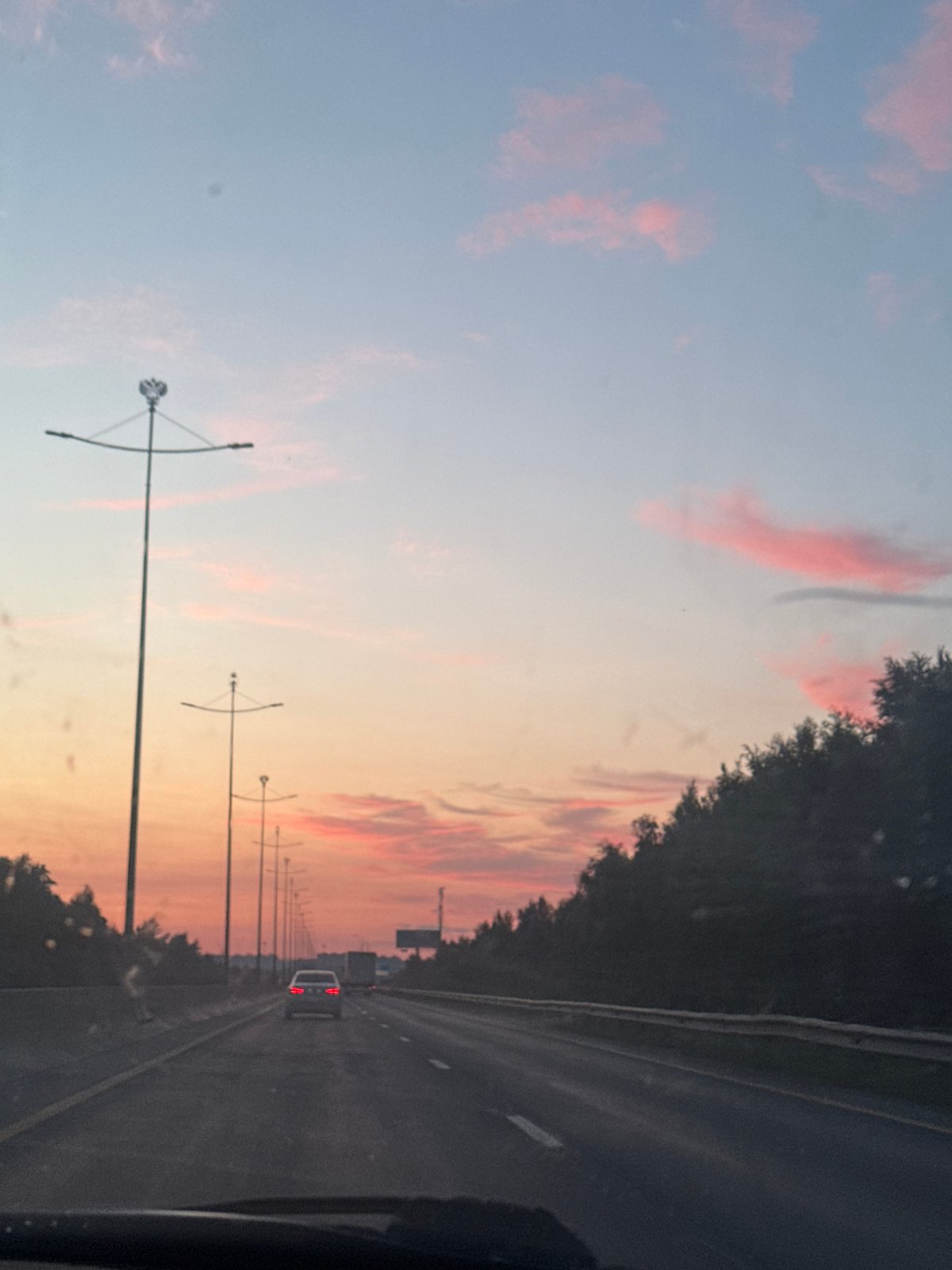 Sunset drive along a Kondratovo highway, soft pink skies