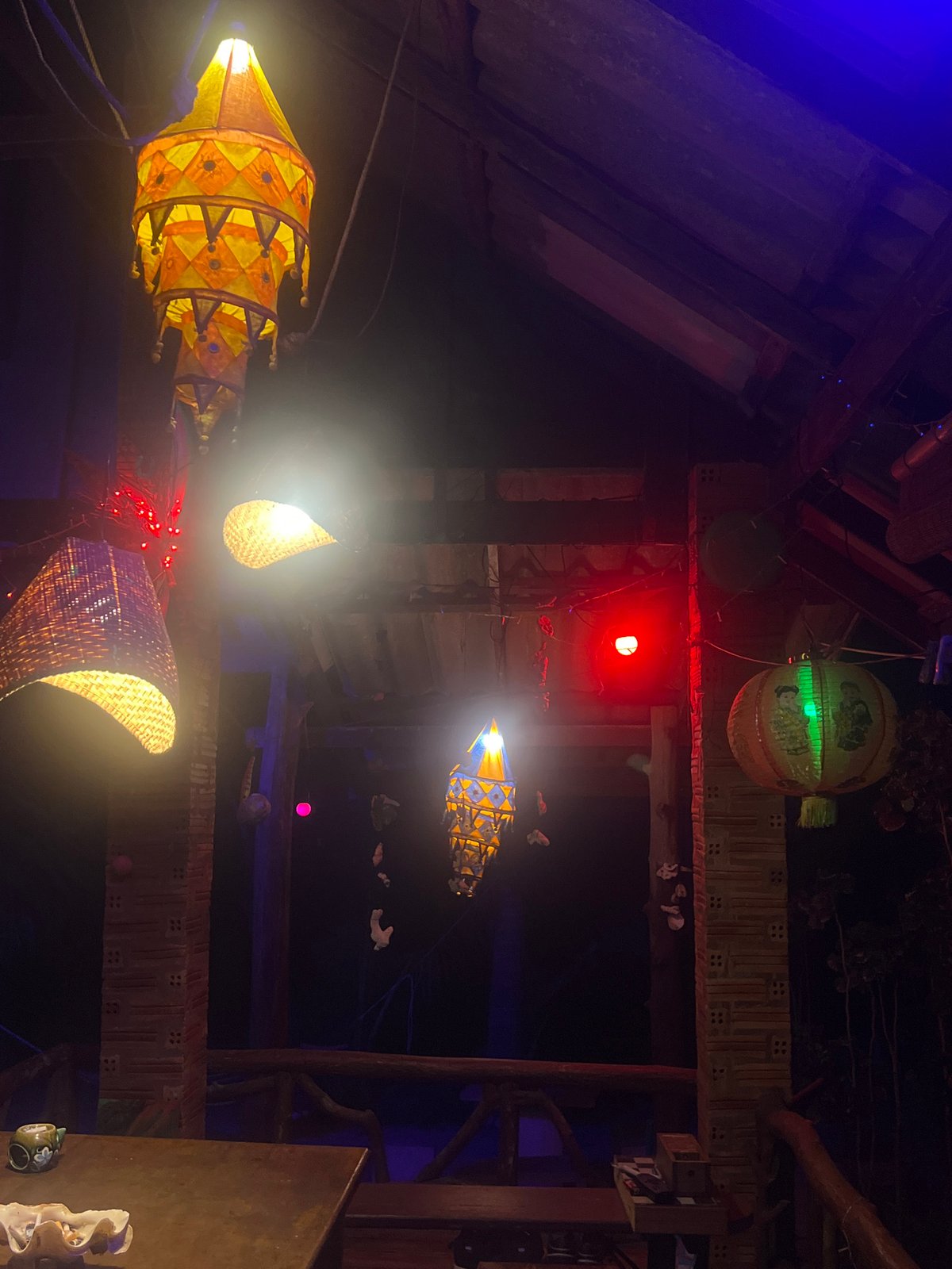 Inside a moody, lantern-lit bohemian bar at night
