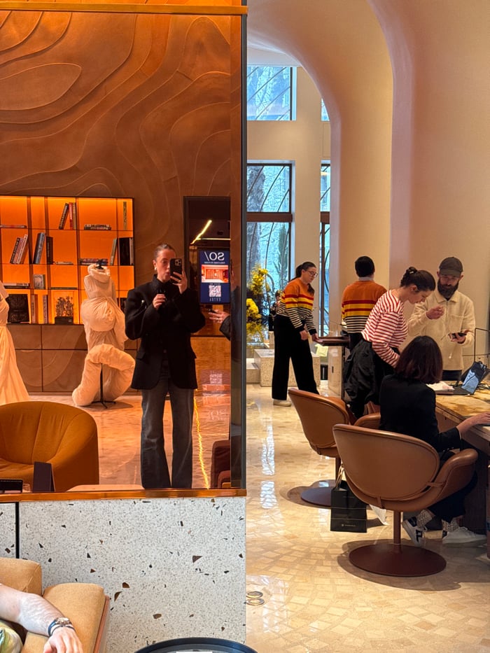 Woman Takes Mirror Selfie in Modern Public Space