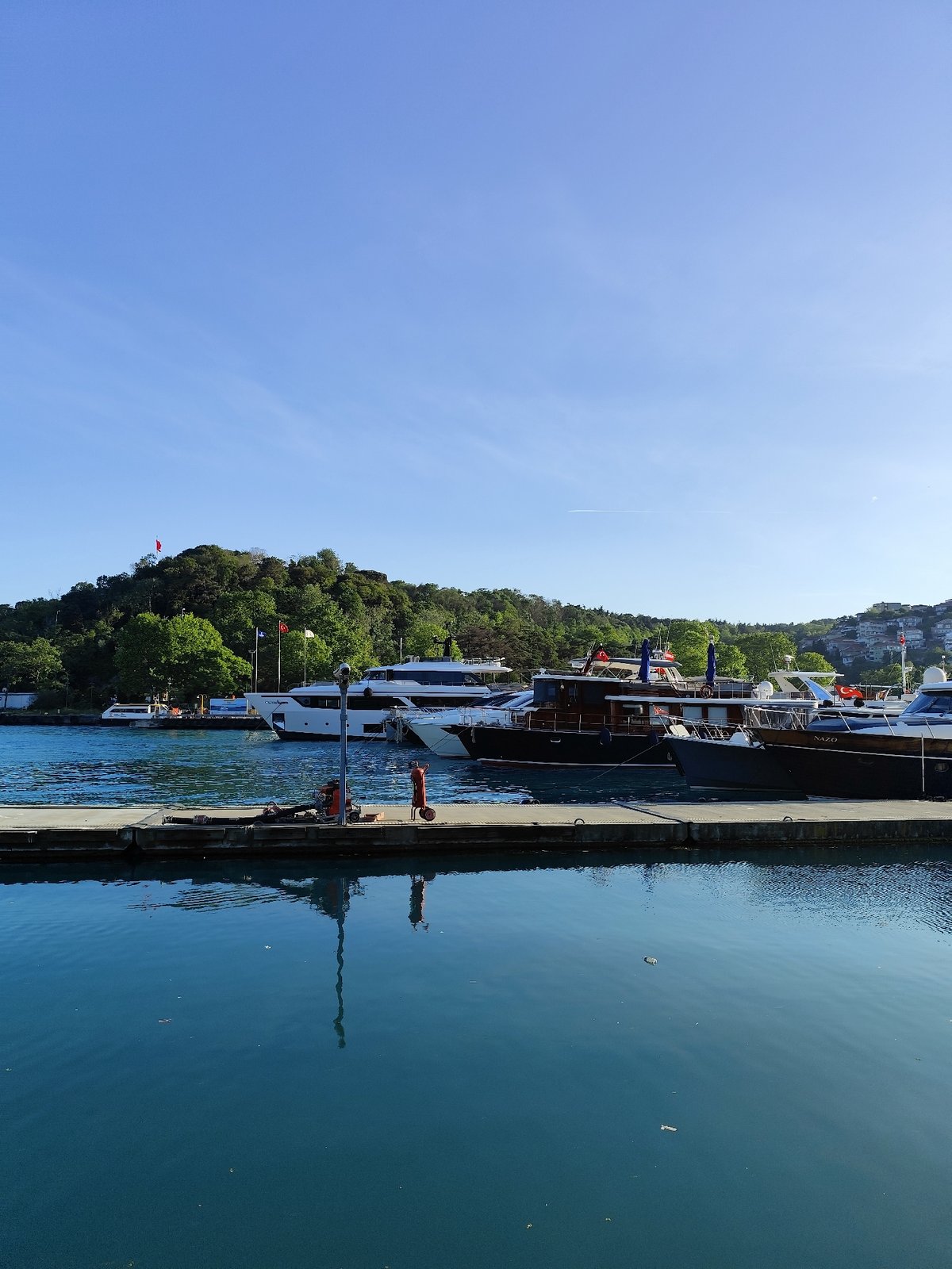Sunny afternoon waterfront activity captured in Sarıyer, Turkey marina