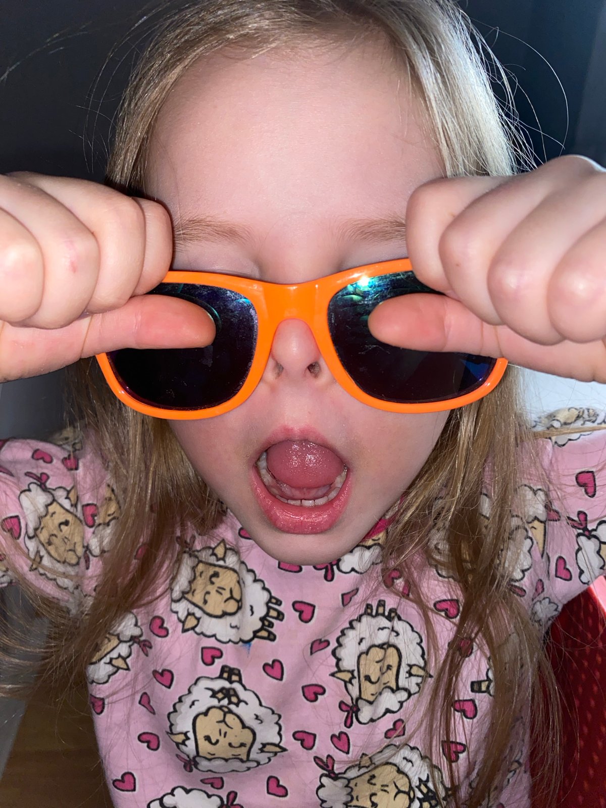 Child plays with orange sunglasses during sunset in Votkinsk
