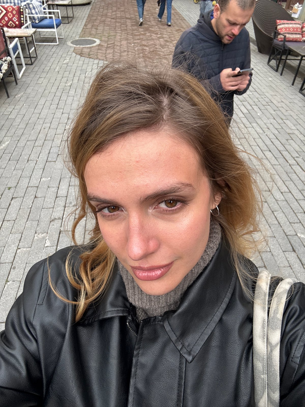 Woman takes selfie in Tbilisi wearing leather jacket