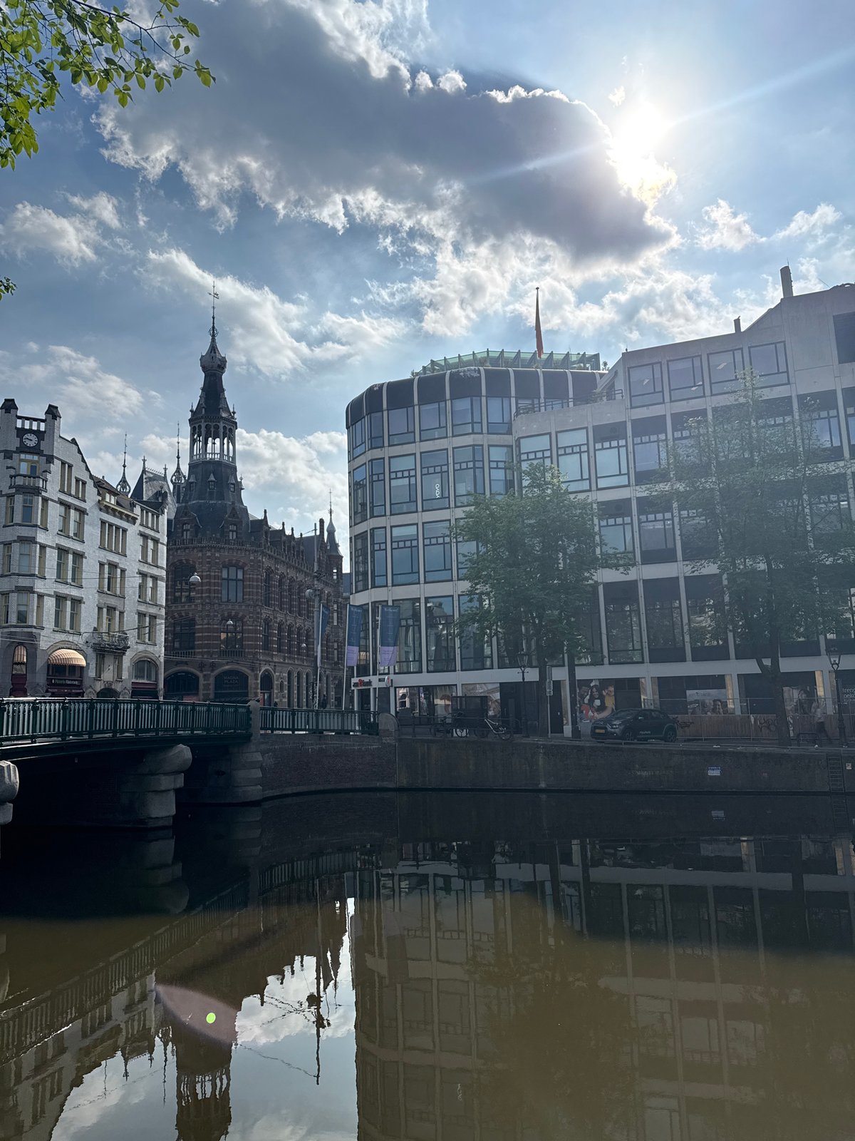 Amsterdam canal reflects mixed architecture in morning documentation