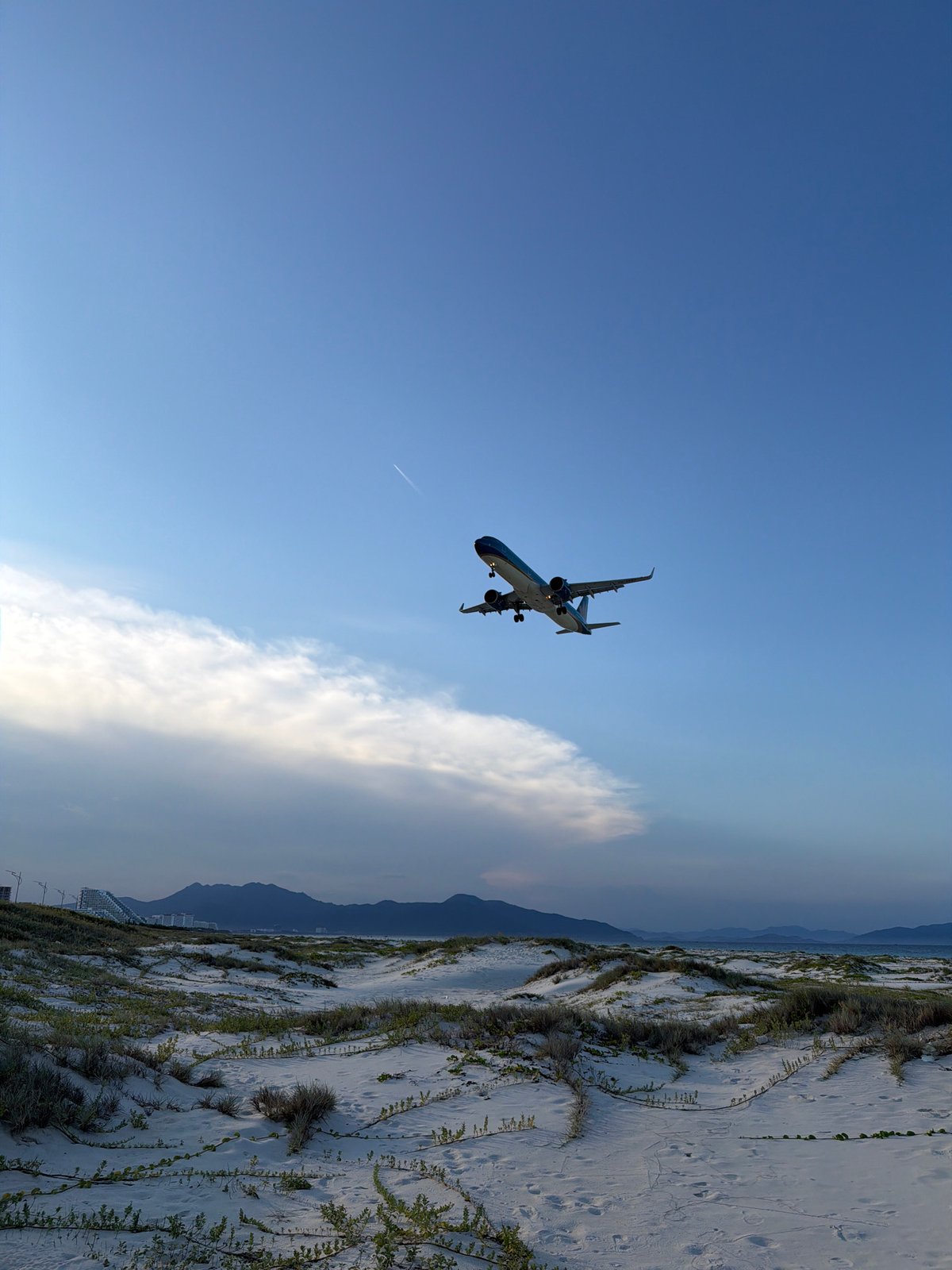 Plane on final approach near Cam Ranh's quiet coastal shoreline