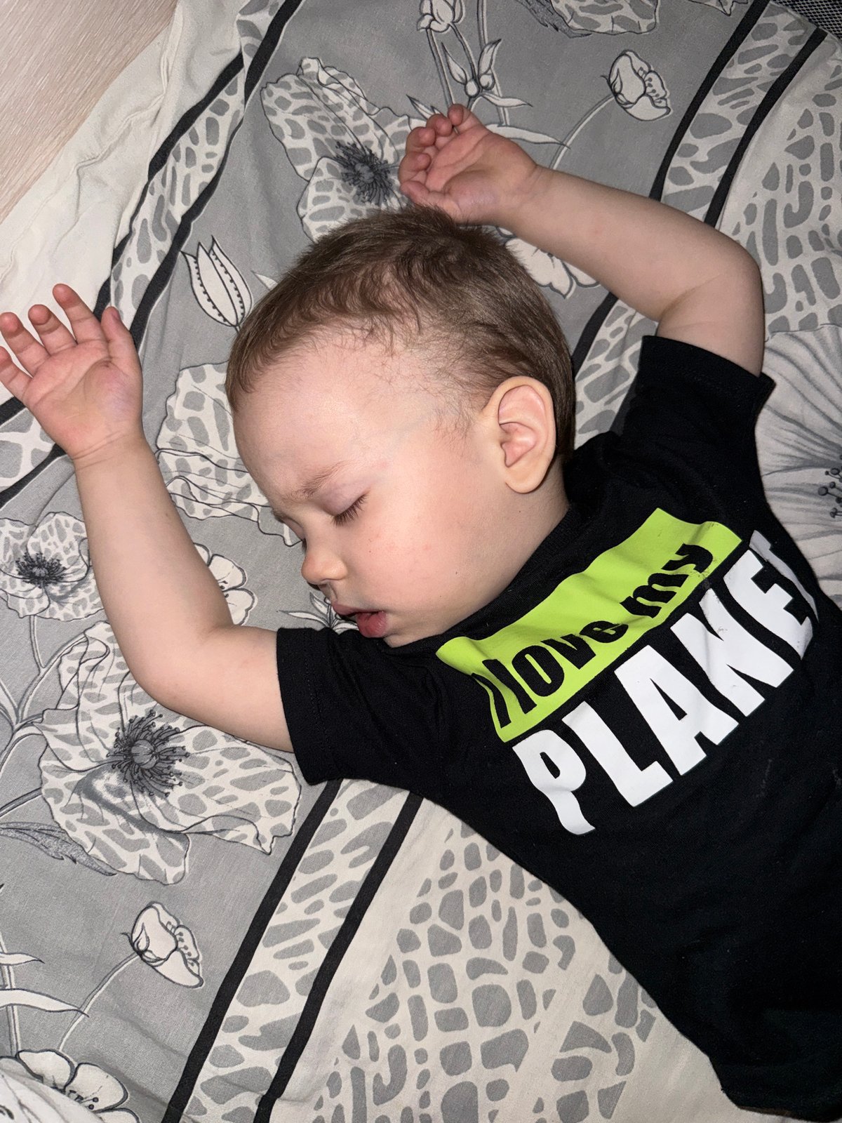 Child sleeps peacefully on patterned bedding in Rusanovo