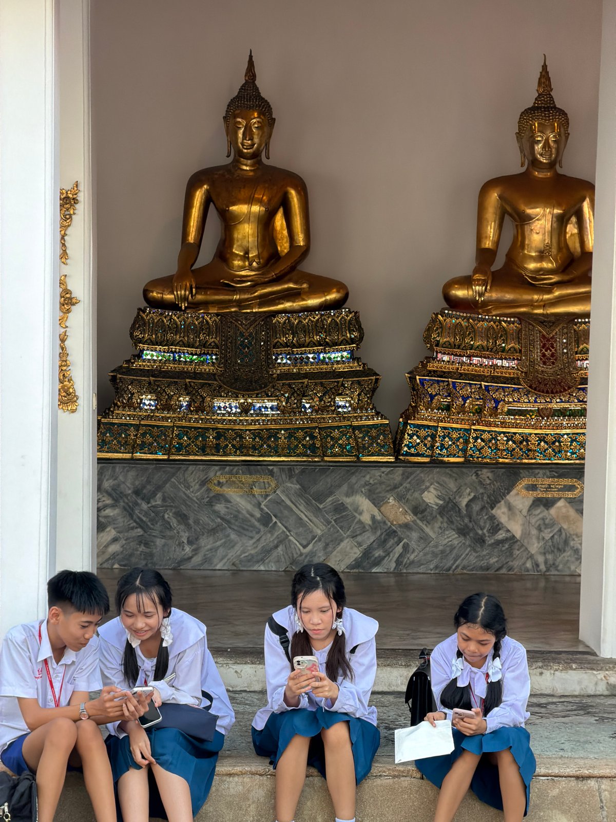 School visit to a Bangkok temple lined with golden Buddha statues
