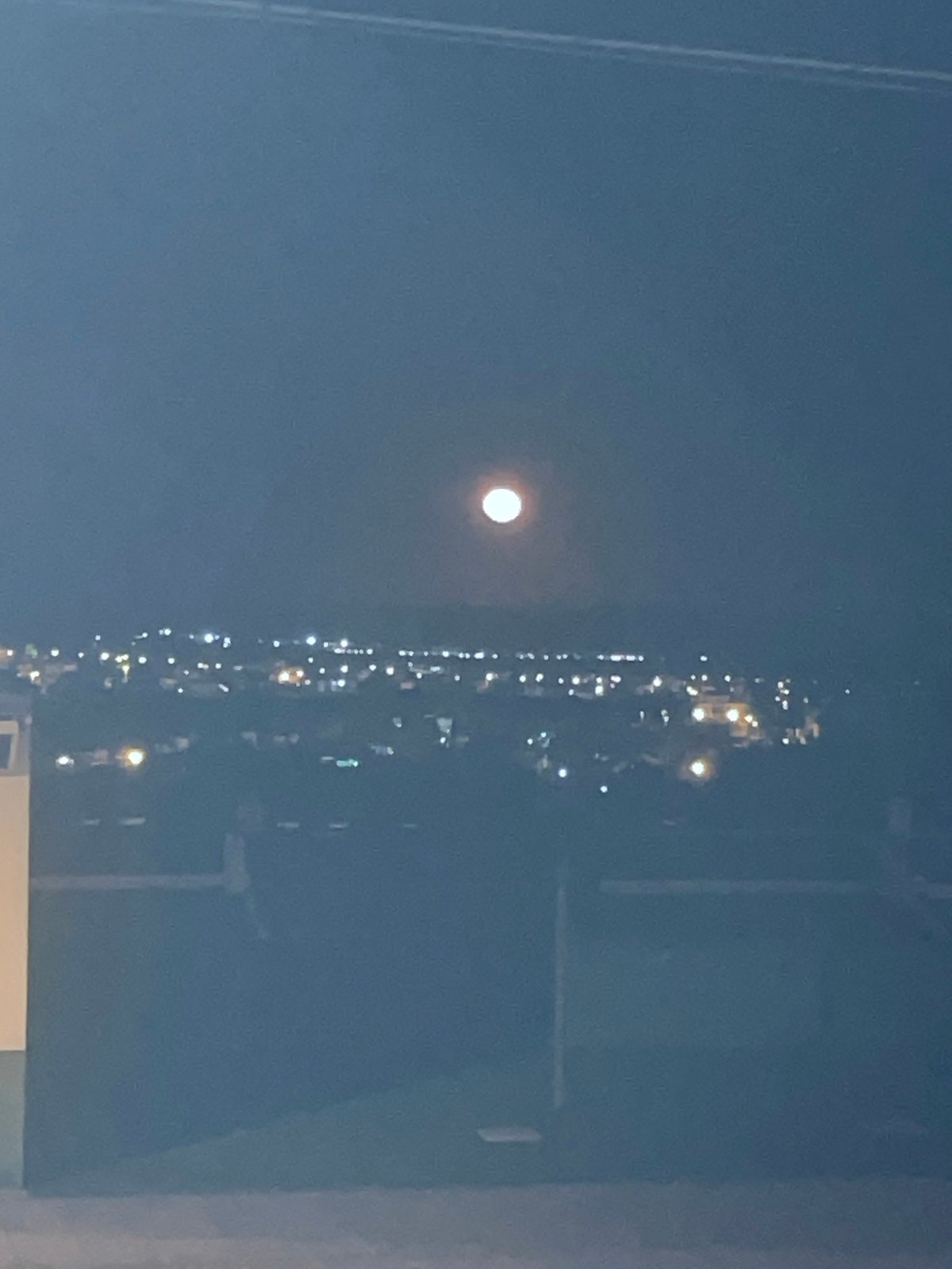 Nighttime moon and illuminated structure photographed in Rojales, Spain