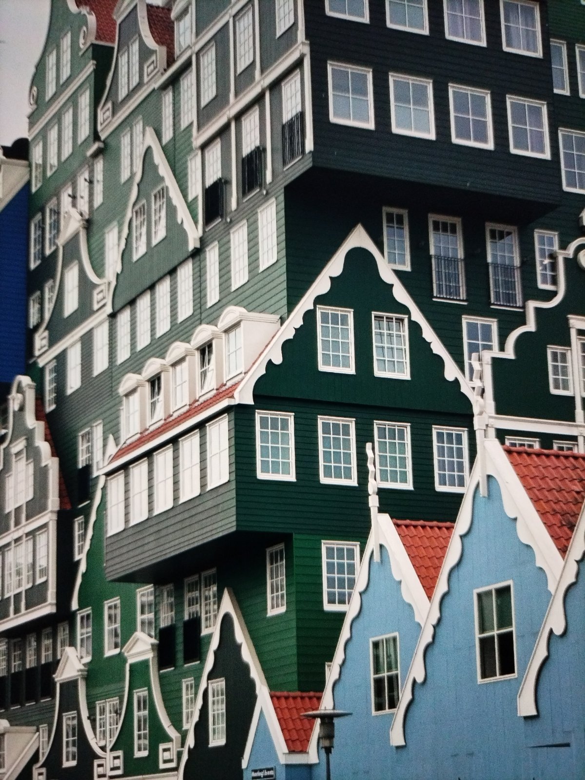 Afternoon hangout at a green Dutch-style building complex.
