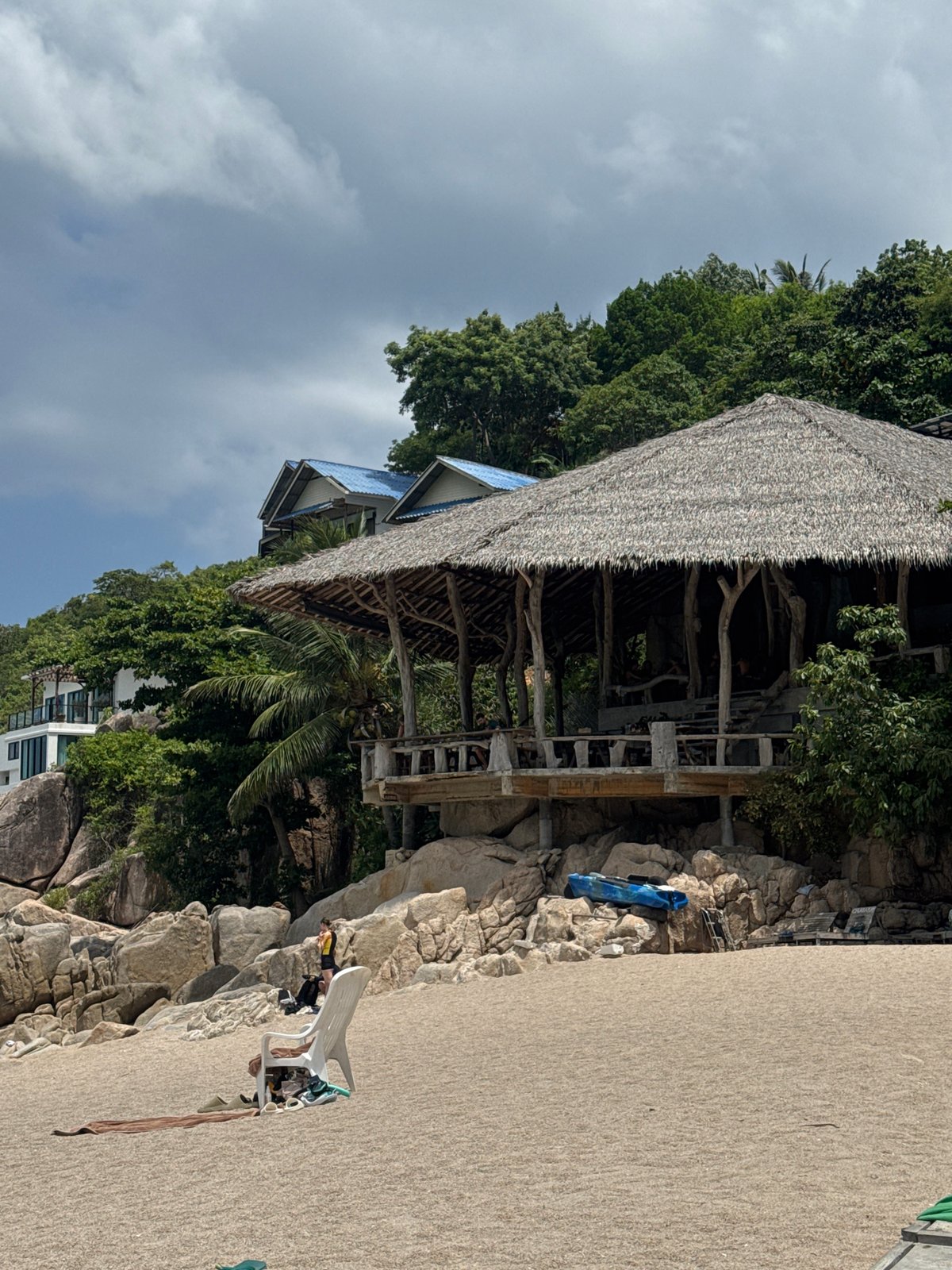 Relaxed day at a tropical beach with kayaks and swimmers