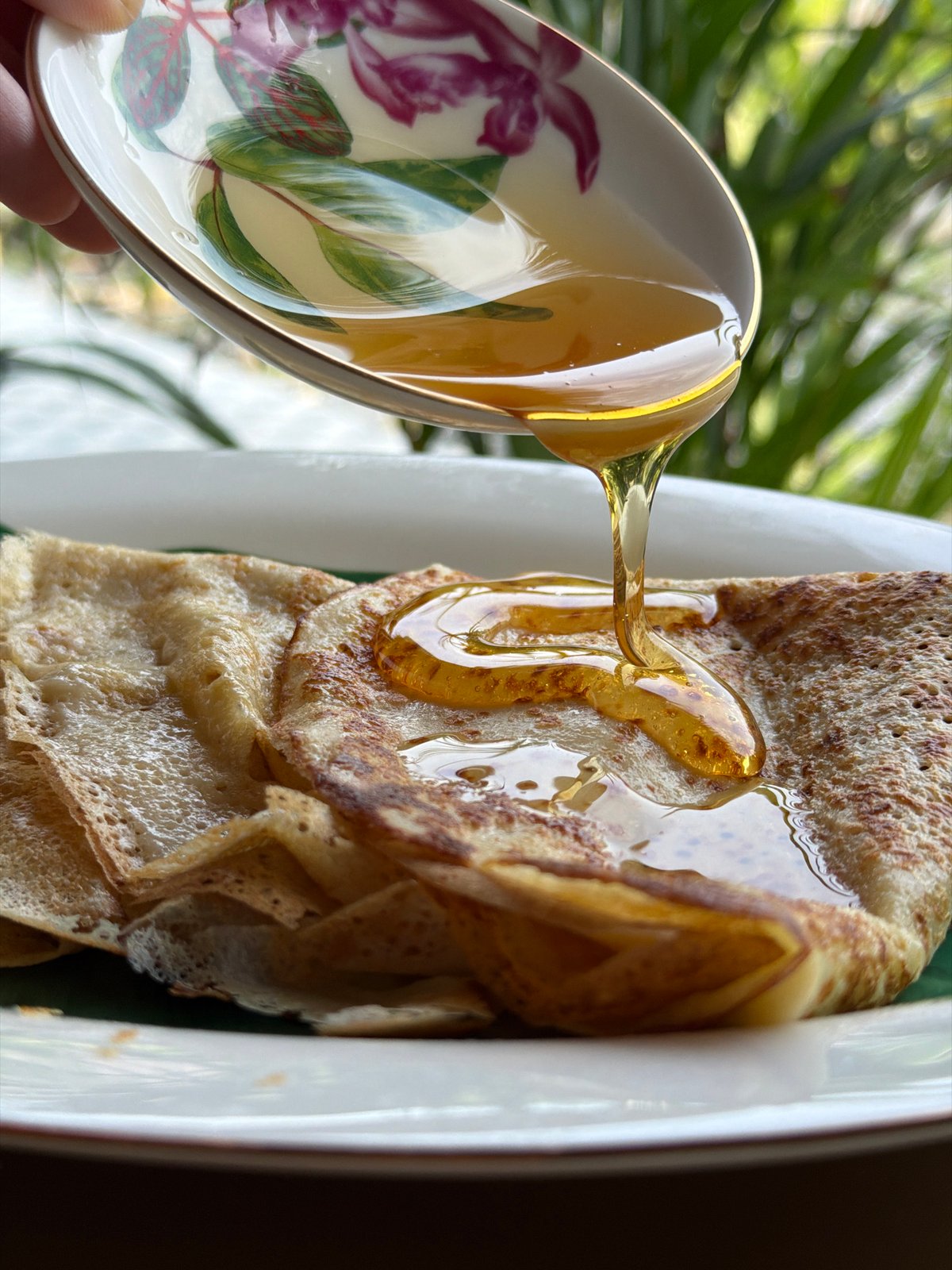 Crepes, honey, and patterned teacups at a Ko Samui café