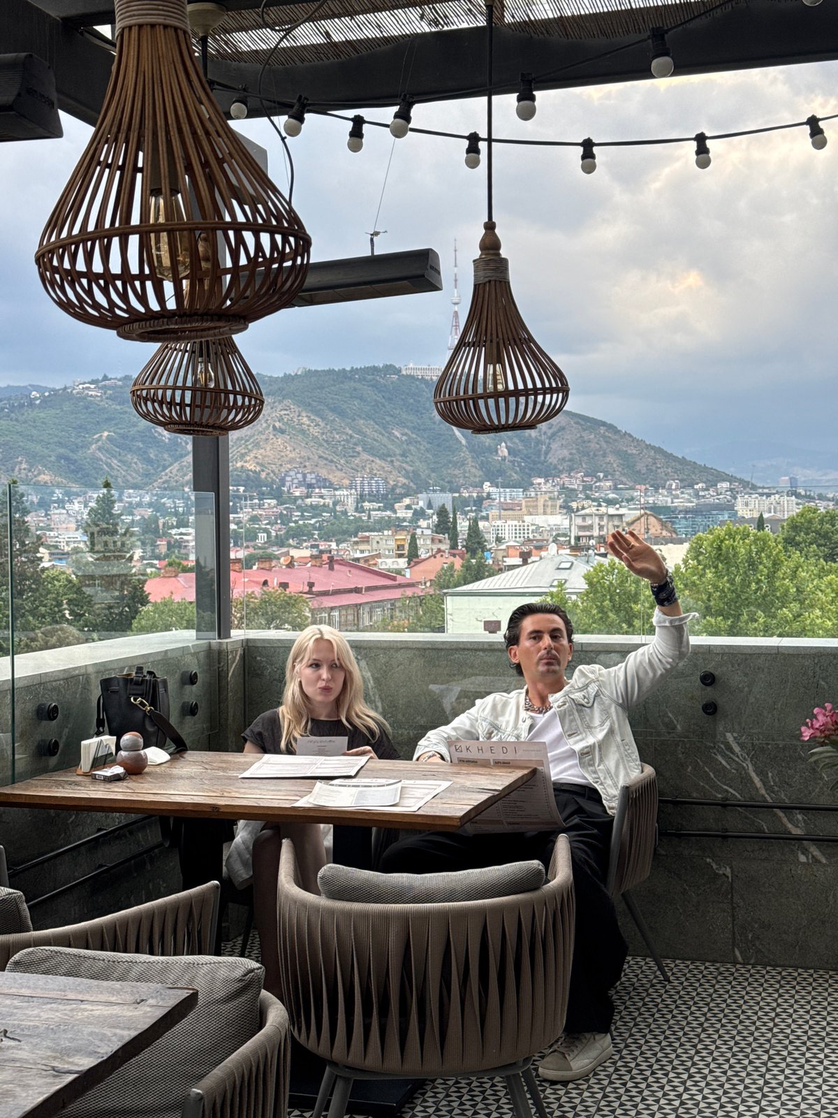 Tbilisi skyline views from a balcony, dramatic skies overhead