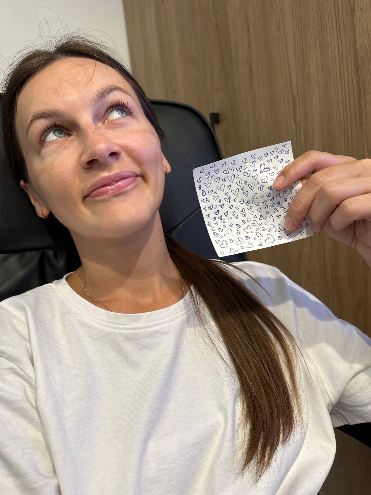 Holding a heart-covered note in a chair in Boreti