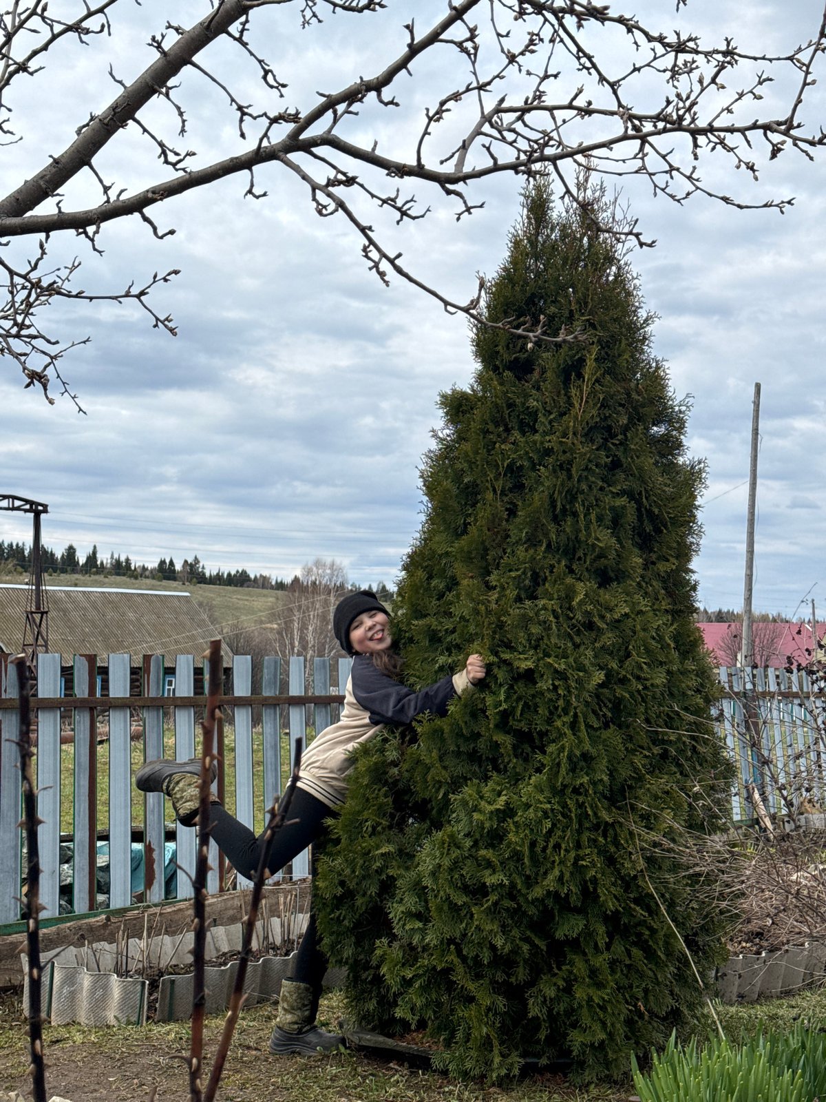 Young person plays hide-and-seek with tabby cat in Russian village