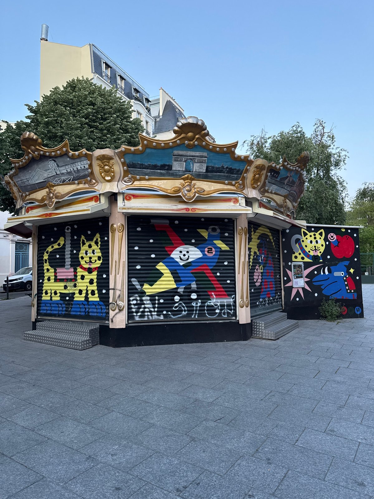 Evening street scenes documented around colorful Parisian kiosk